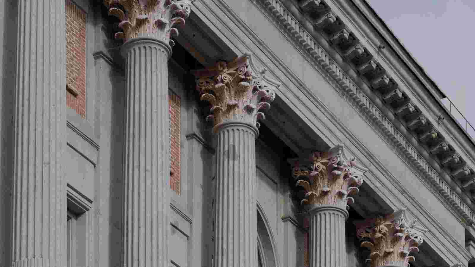 La imagen muestra una serie de columnas decorativas con detalles arquitectónicos en un edificio.