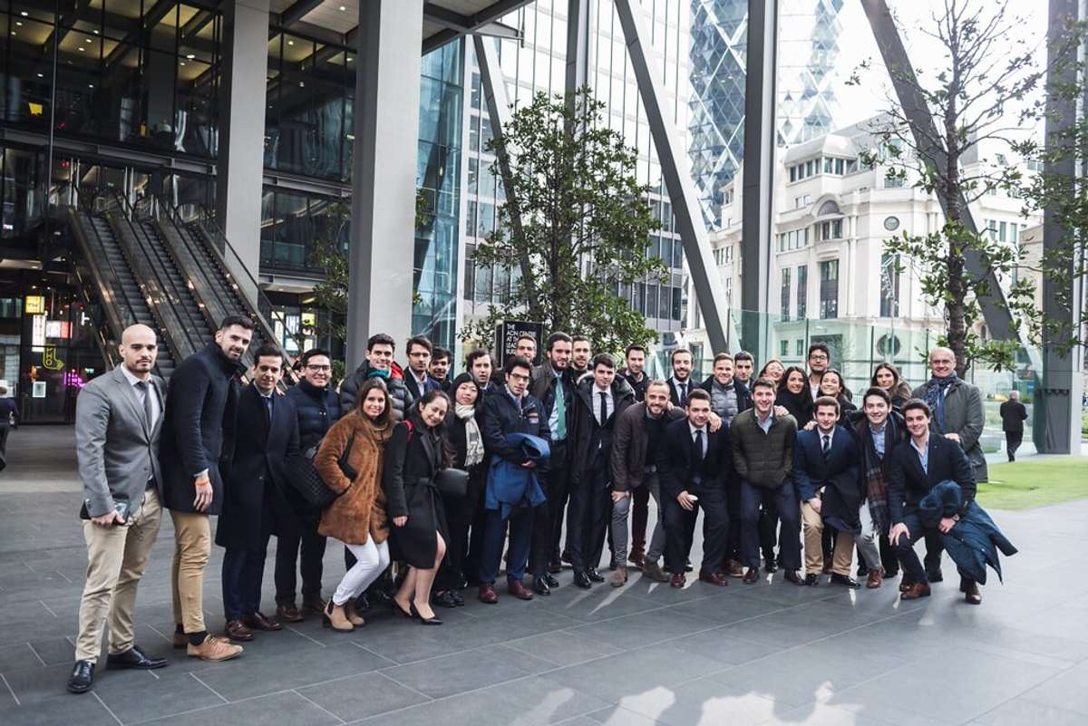Un grupo numeroso de personas posando en un entorno urbano moderno.