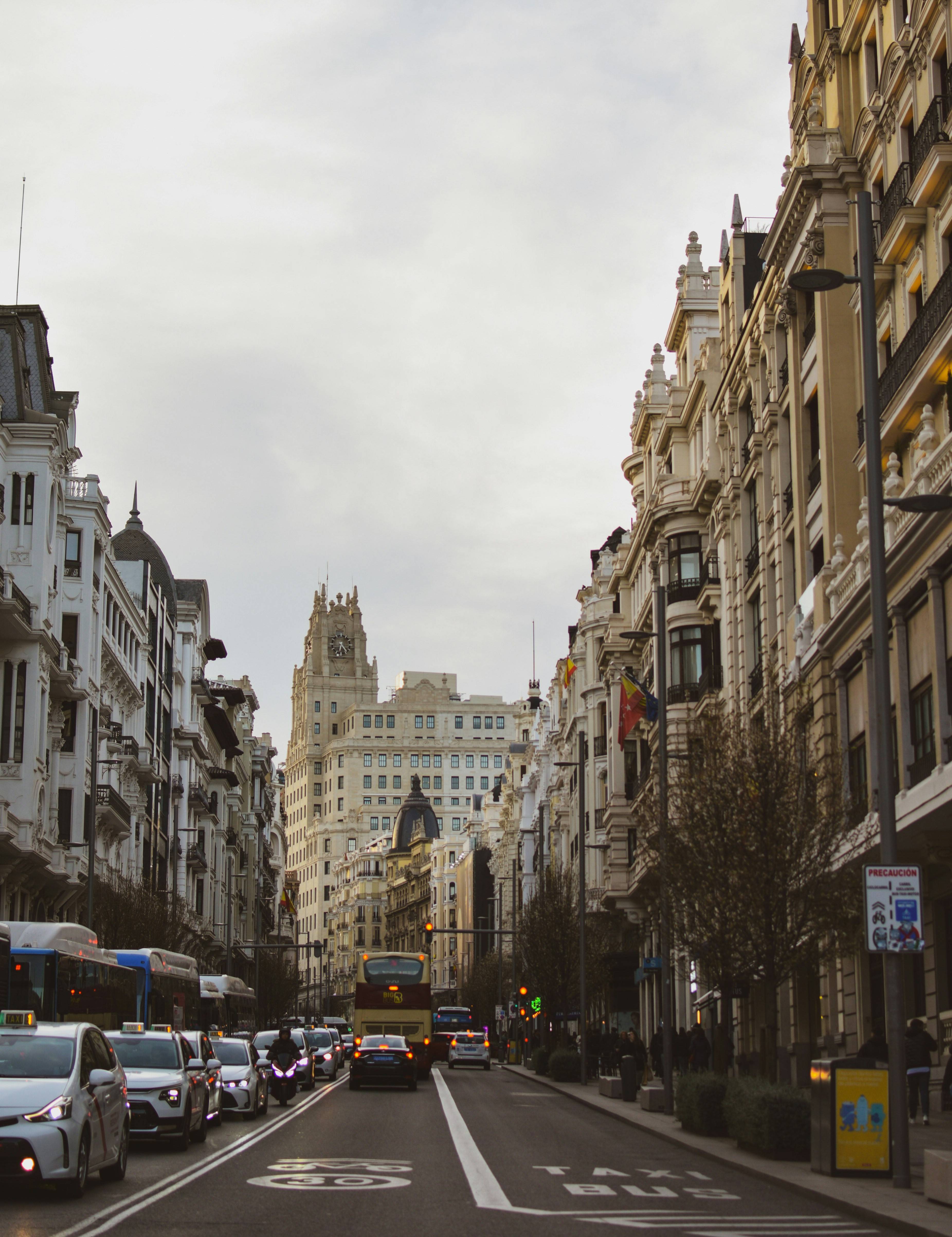 Una vista de una calle en una ciudad con edificios elegantes y tráfico vehicular.