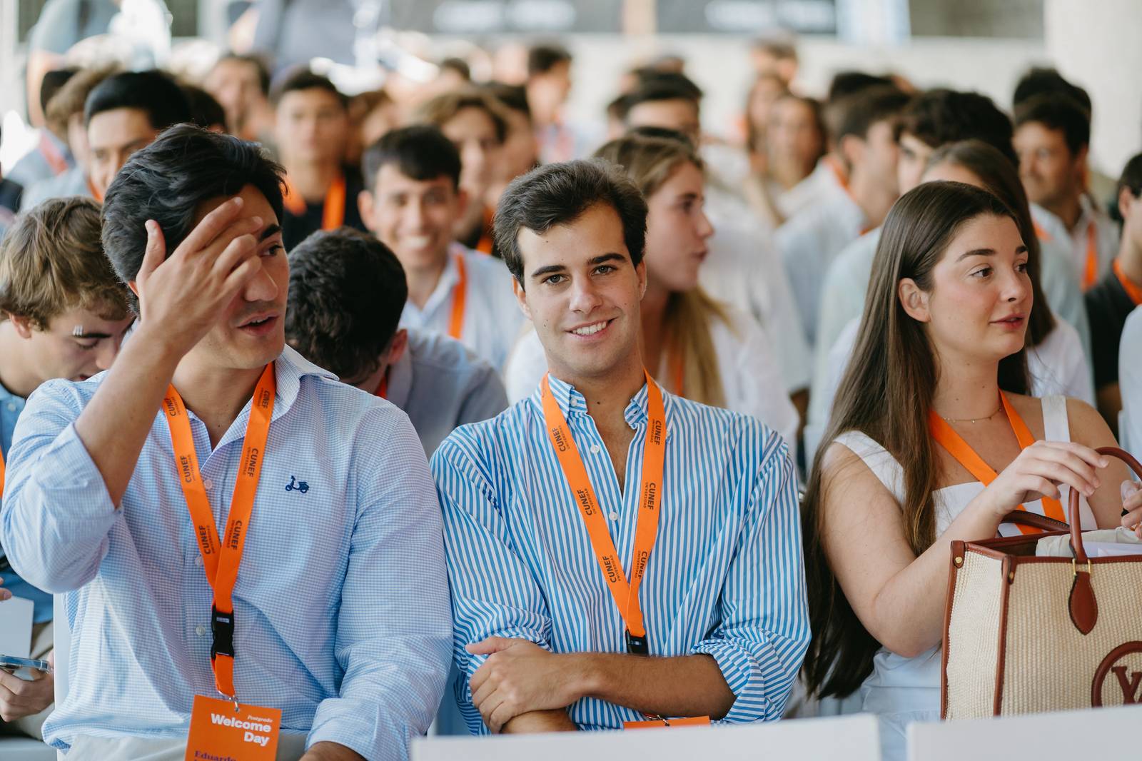 Un grupo de jóvenes en un evento, sentados y con tarjetas de identificación.