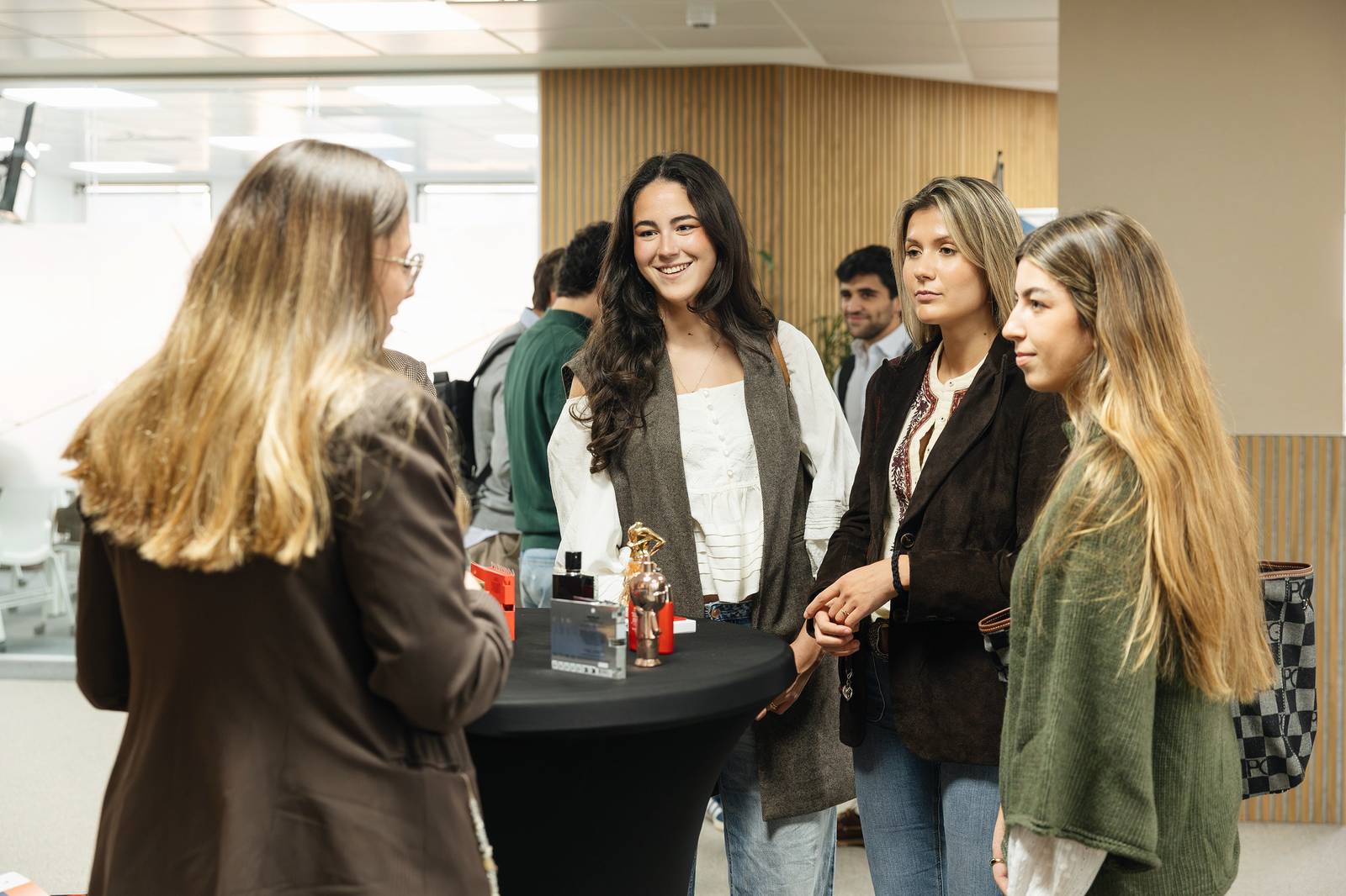 Un grupo de cuatro personas conversando en un ambiente social y profesional.