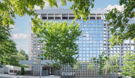 Edificio moderno con un diseño arquitectónico distintivo rodeado de árboles.