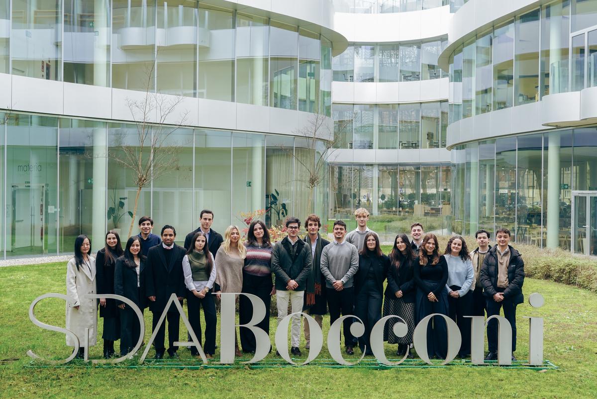 Grupo de personas posando frente a un edificio moderno de la SDA Bocconi.