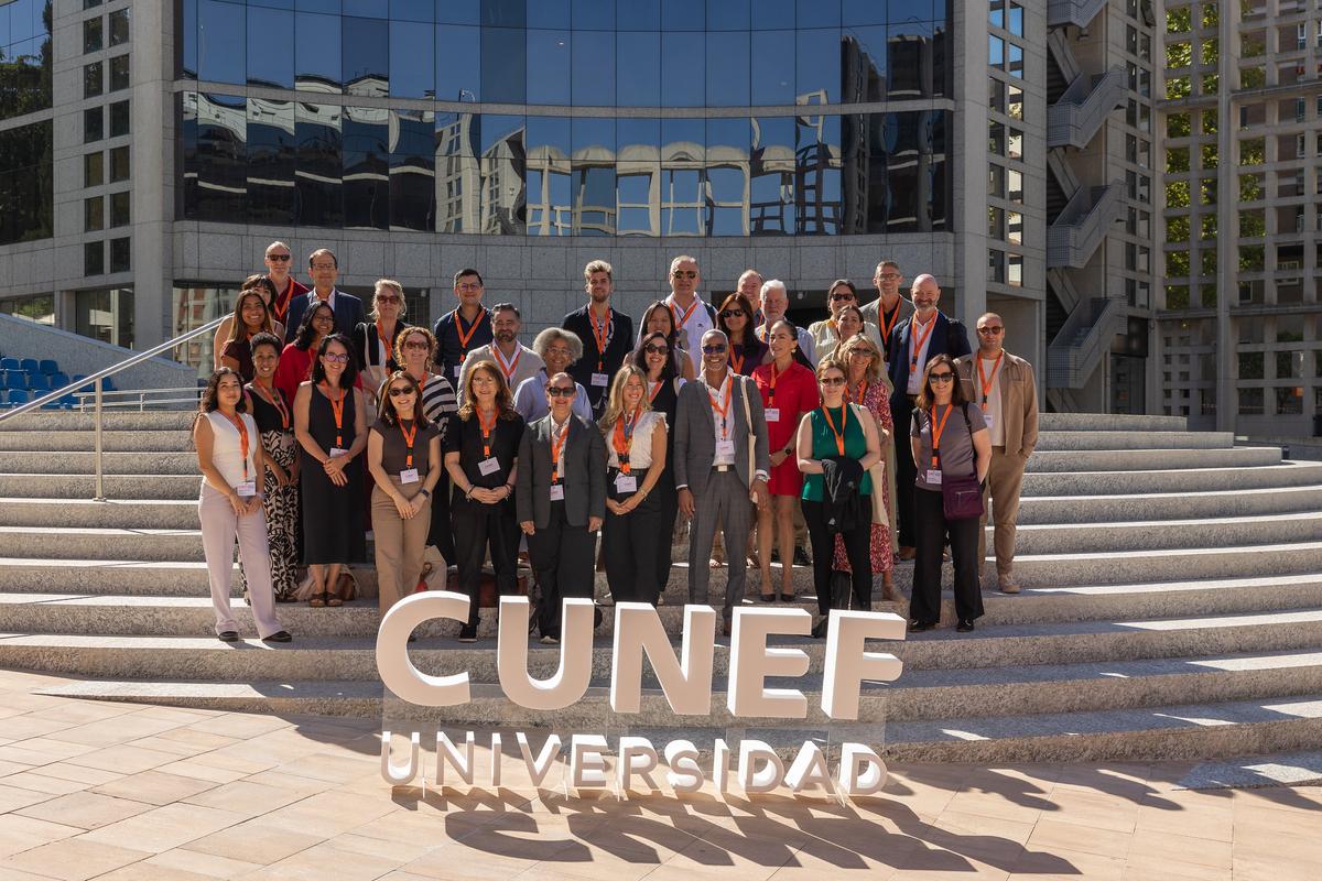 Grupo de personas posando frente a un edificio con el nombre de CUNEF Universidad.