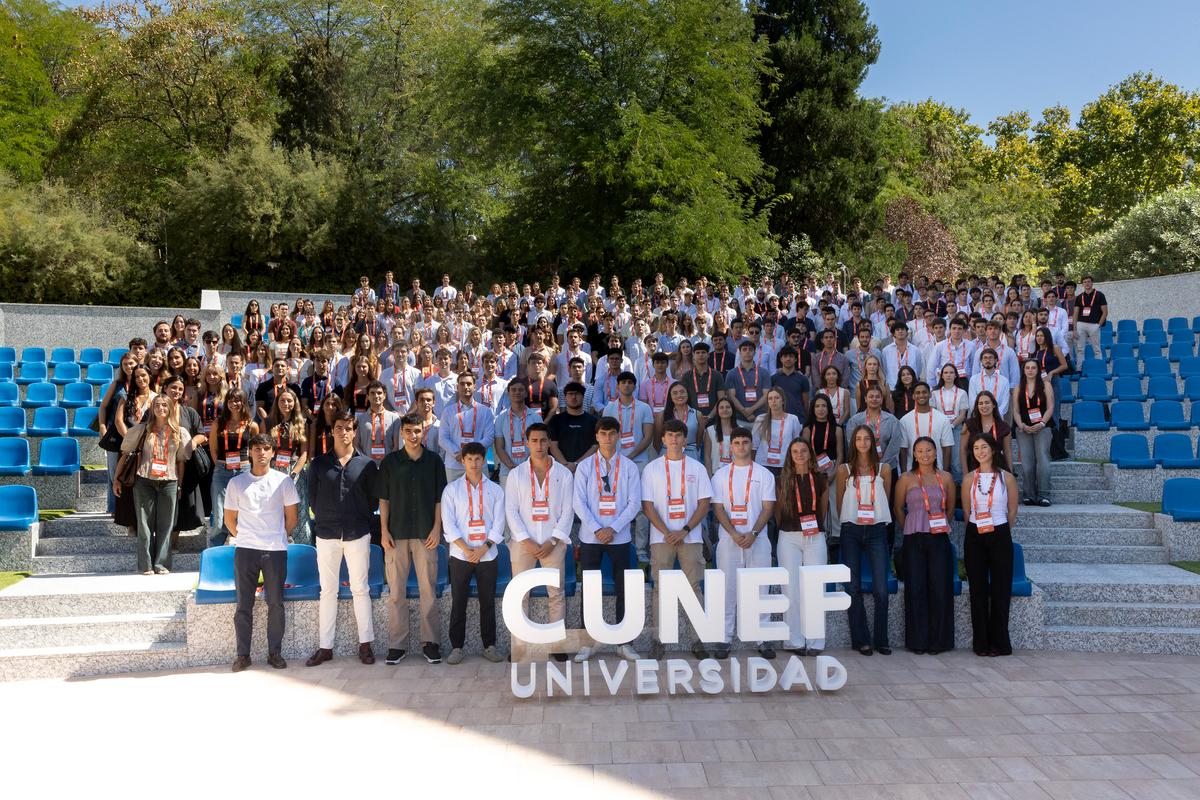 La imagen muestra a un gran grupo de estudiantes reunidos en un espacio al aire libre, todos sonrientes y posando para la cámara.