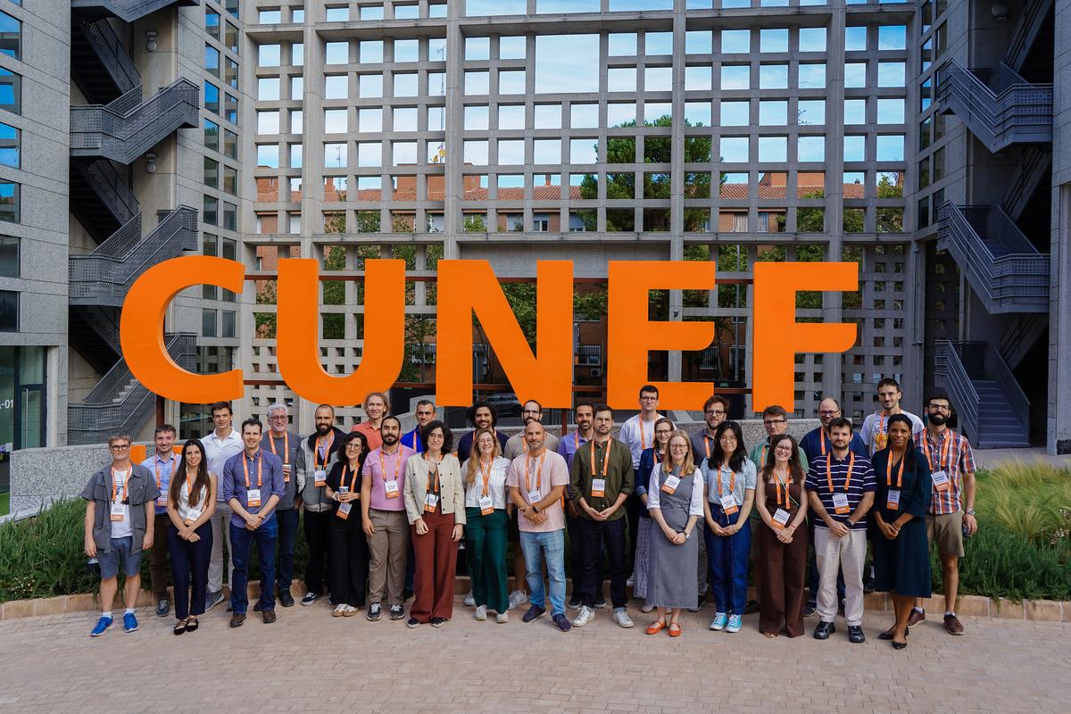 Un grupo de personas posando frente a un gran letrero con la palabra CUNEF en un entorno urbano.