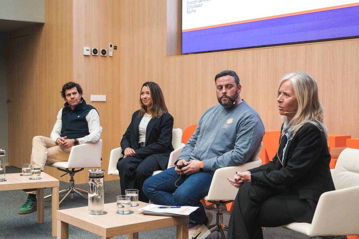 Un panel de discusión con cuatro ponentes en un ambiente académico.