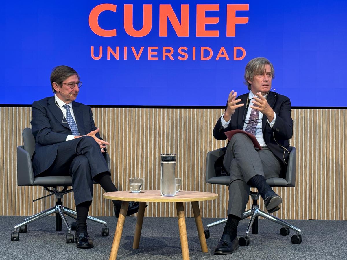 Dos hombres sentados en un escenario durante un evento de la universidad CUNEF.