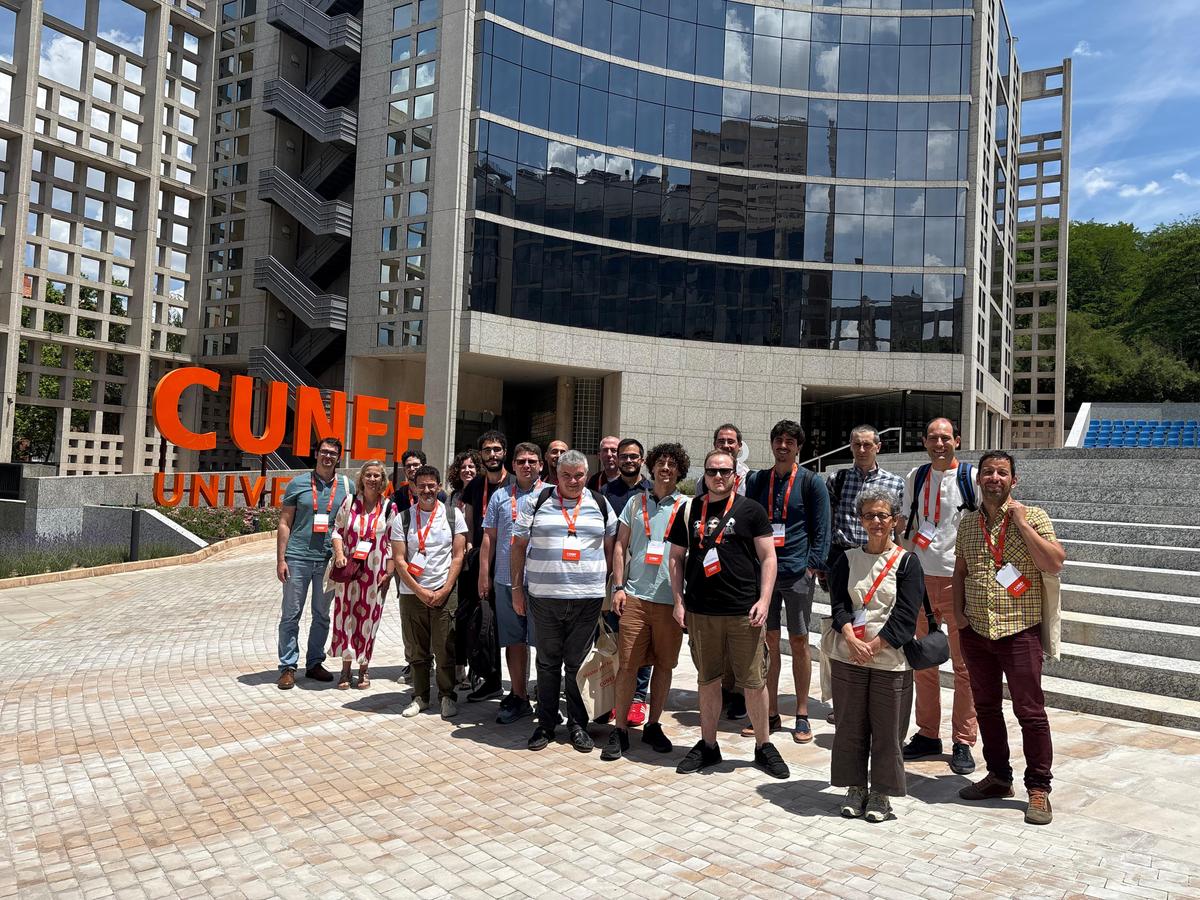 Grupo de personas posando frente al edificio de CUNEF en un día soleado.