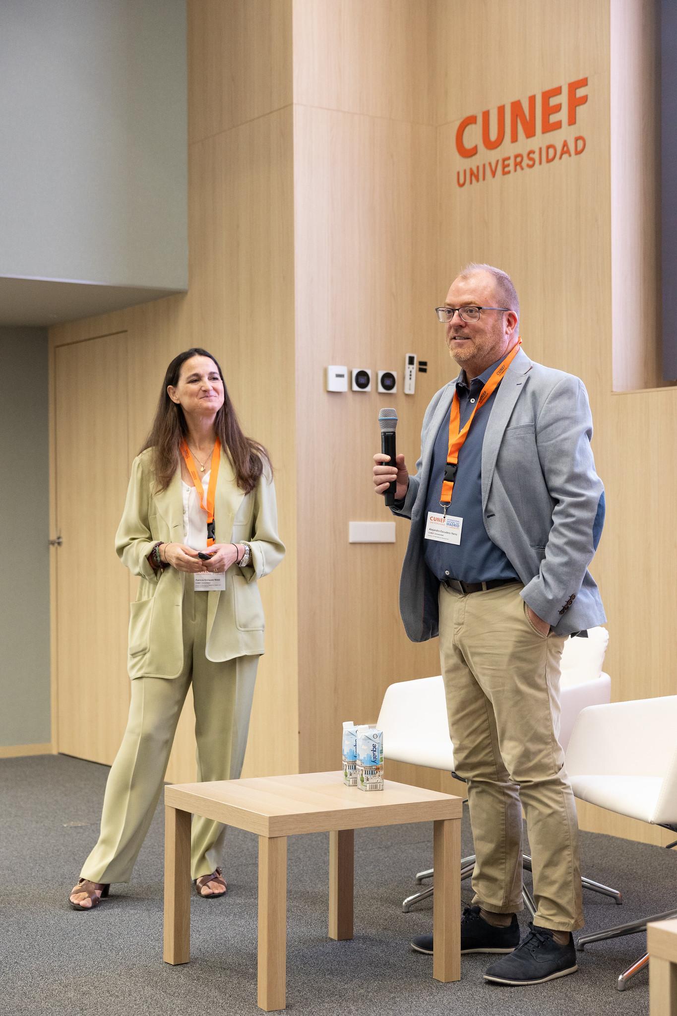 Dos personas están realizando una presentación en un evento en la universidad CUNEF.