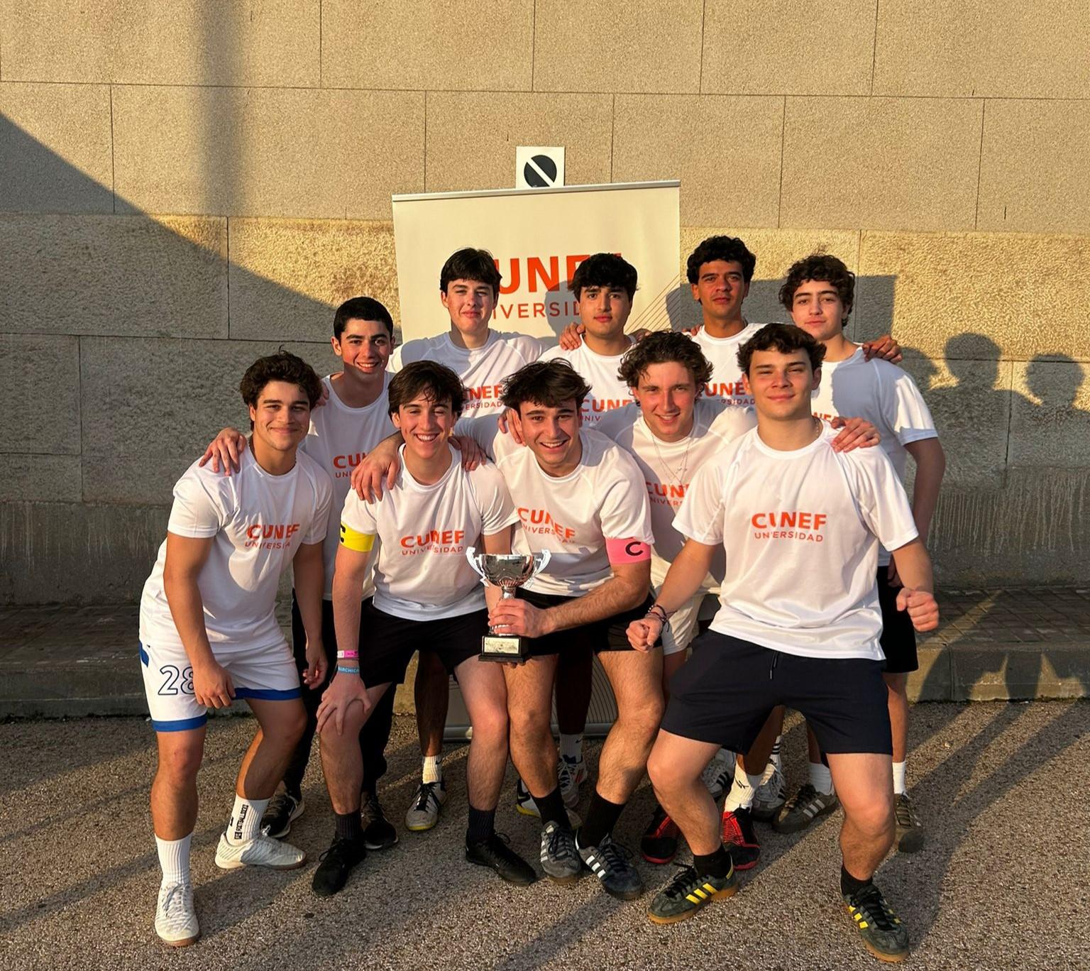 Un grupo de jóvenes celebra con un trofeo en un evento deportivo.