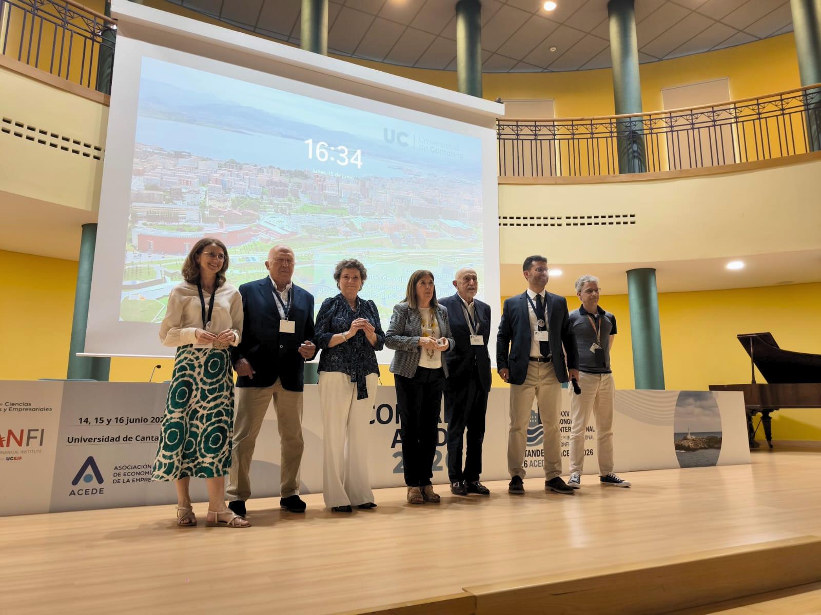 Un grupo de personas en un escenario durante un evento académico.