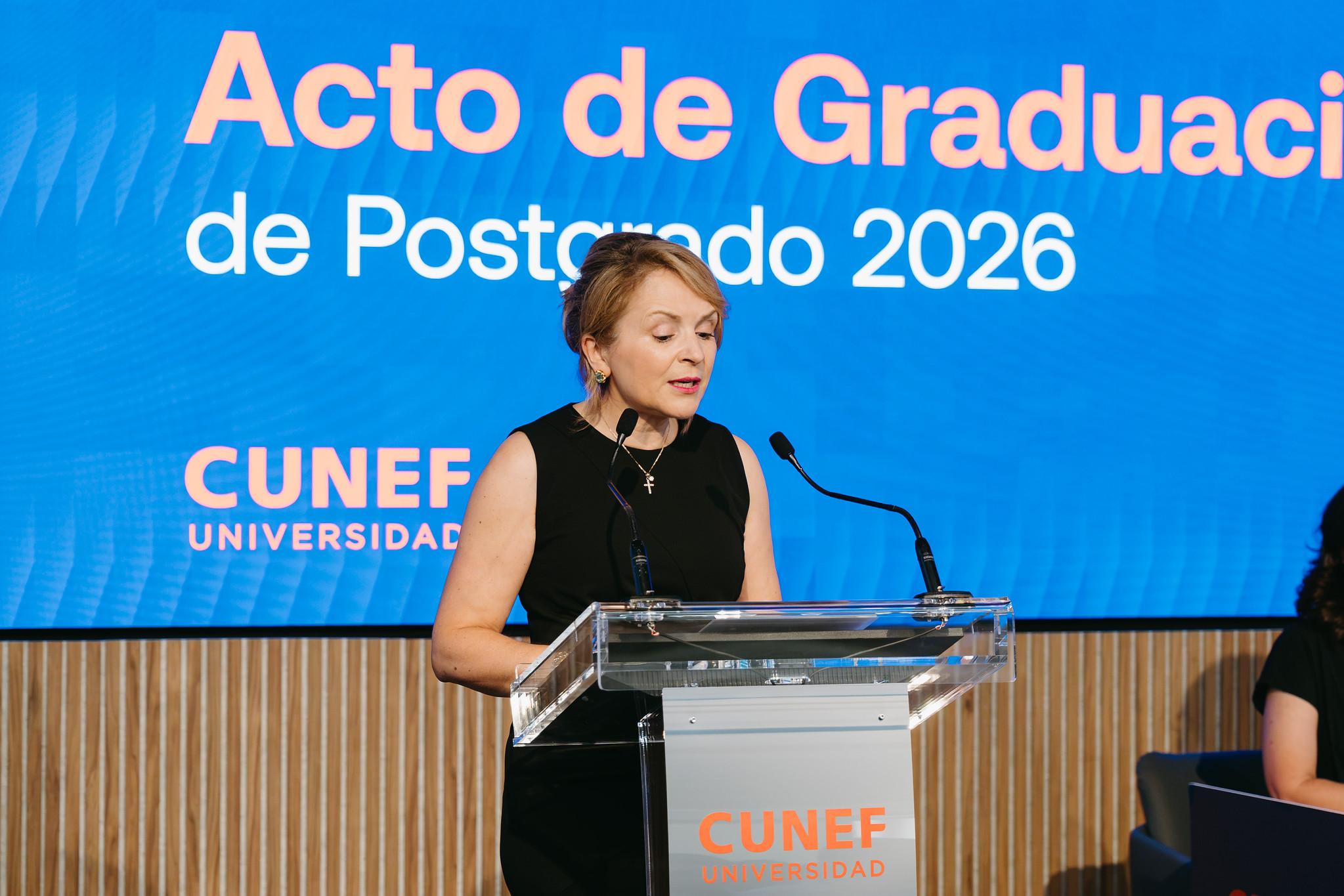 Una mujer habla en un podio durante el acto de graduación de posgrado en CUNEF.