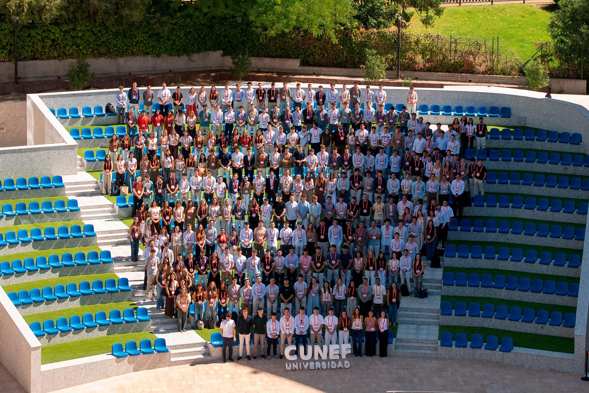 Fotografía grupal en un auditorio al aire libre con muchas personas sentadas en gradas.