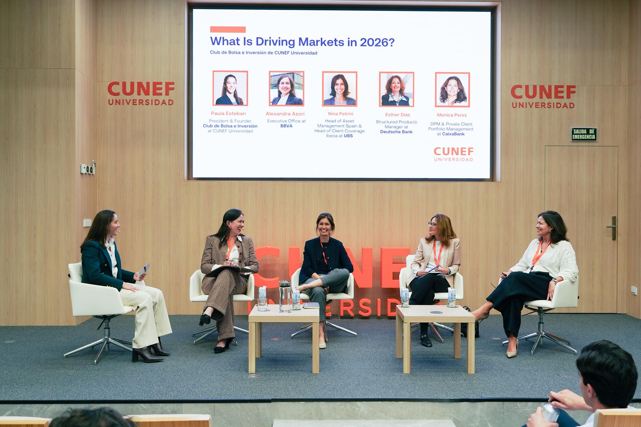 Una mesa redonda en un evento sobre mercados con cinco panelistas en un auditorio.