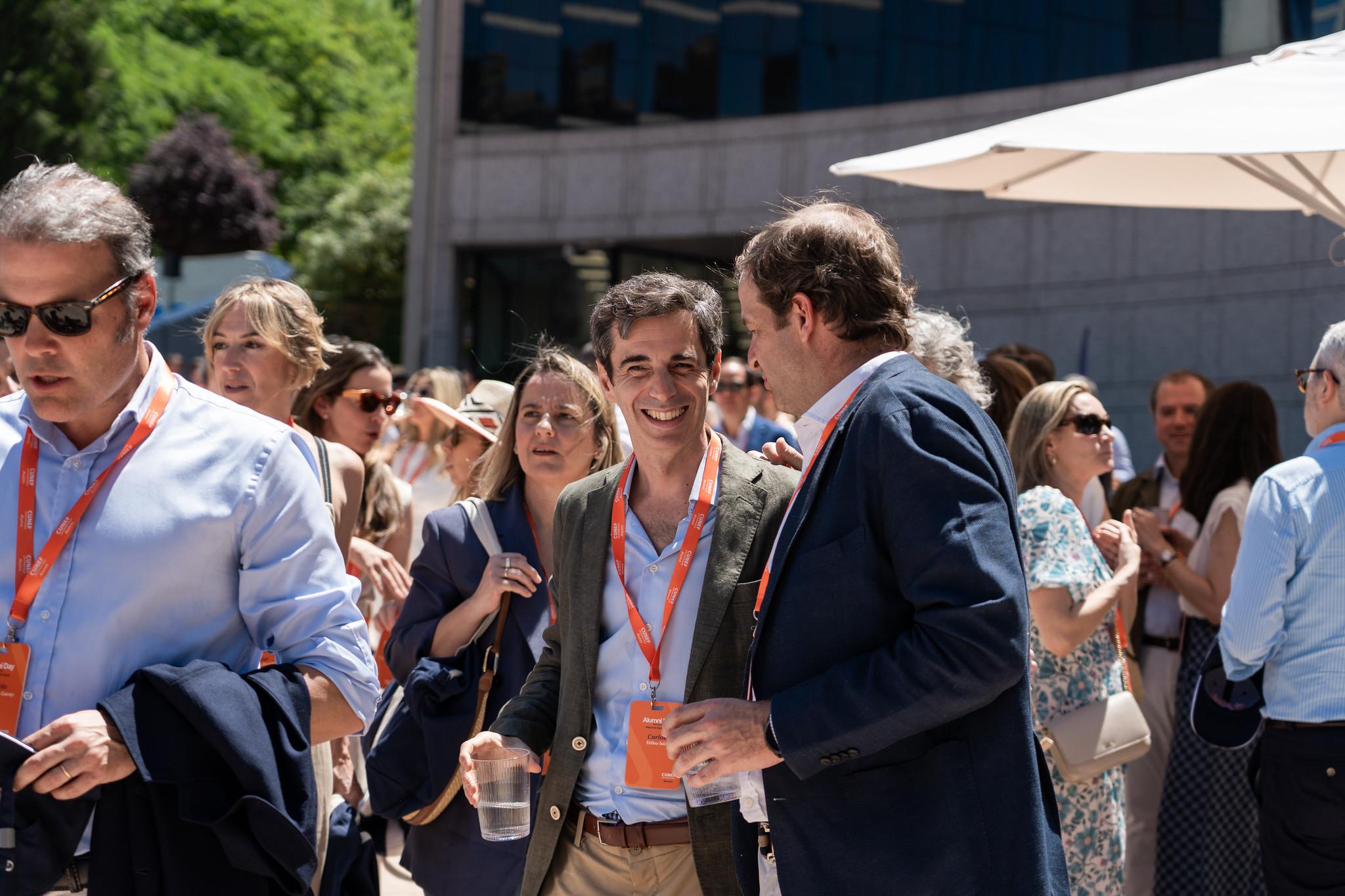 Un grupo de personas socializando en un evento al aire libre en un día soleado.