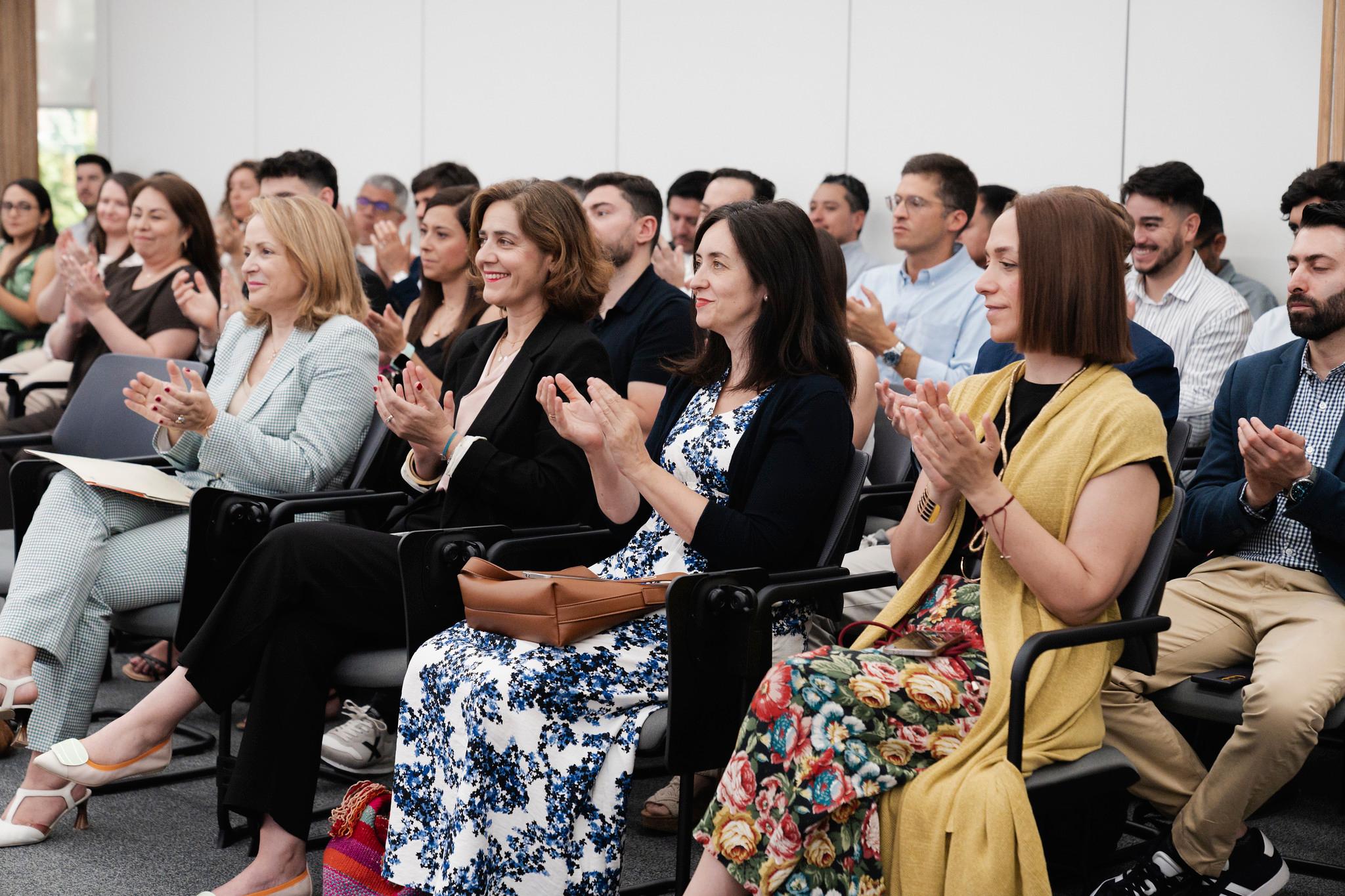 Un grupo de personas aplaudiendo en un evento o presentación.