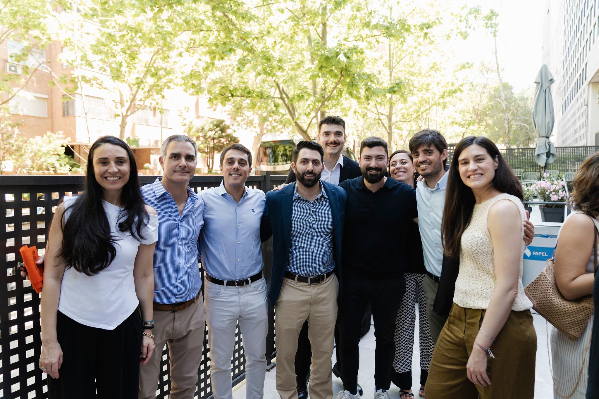 Un grupo de personas sonriendo y posando juntas al aire libre en un ambiente soleado.