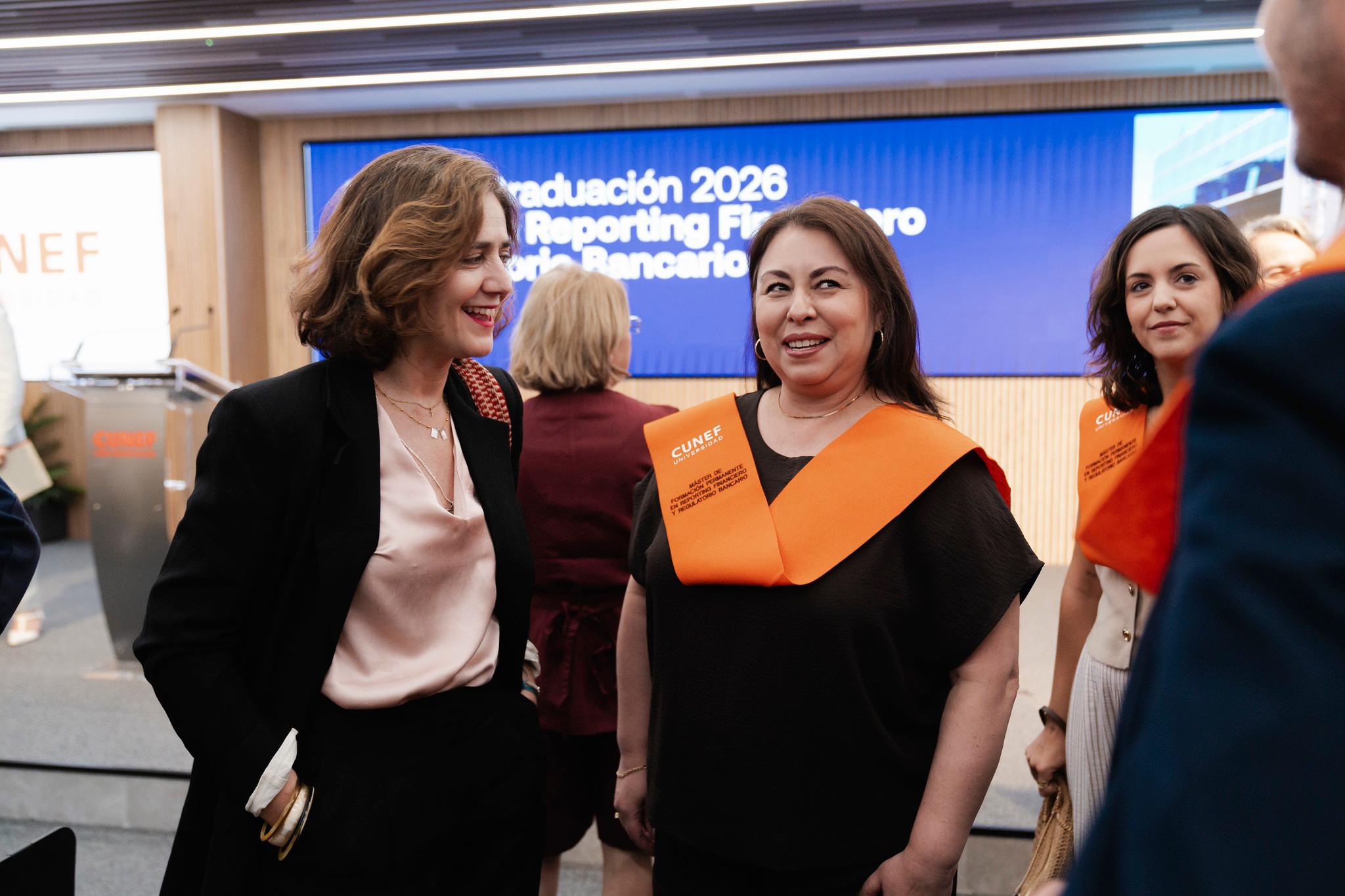 Una reunión de graduación con varias mujeres sonrientes vestidas de manera formal.