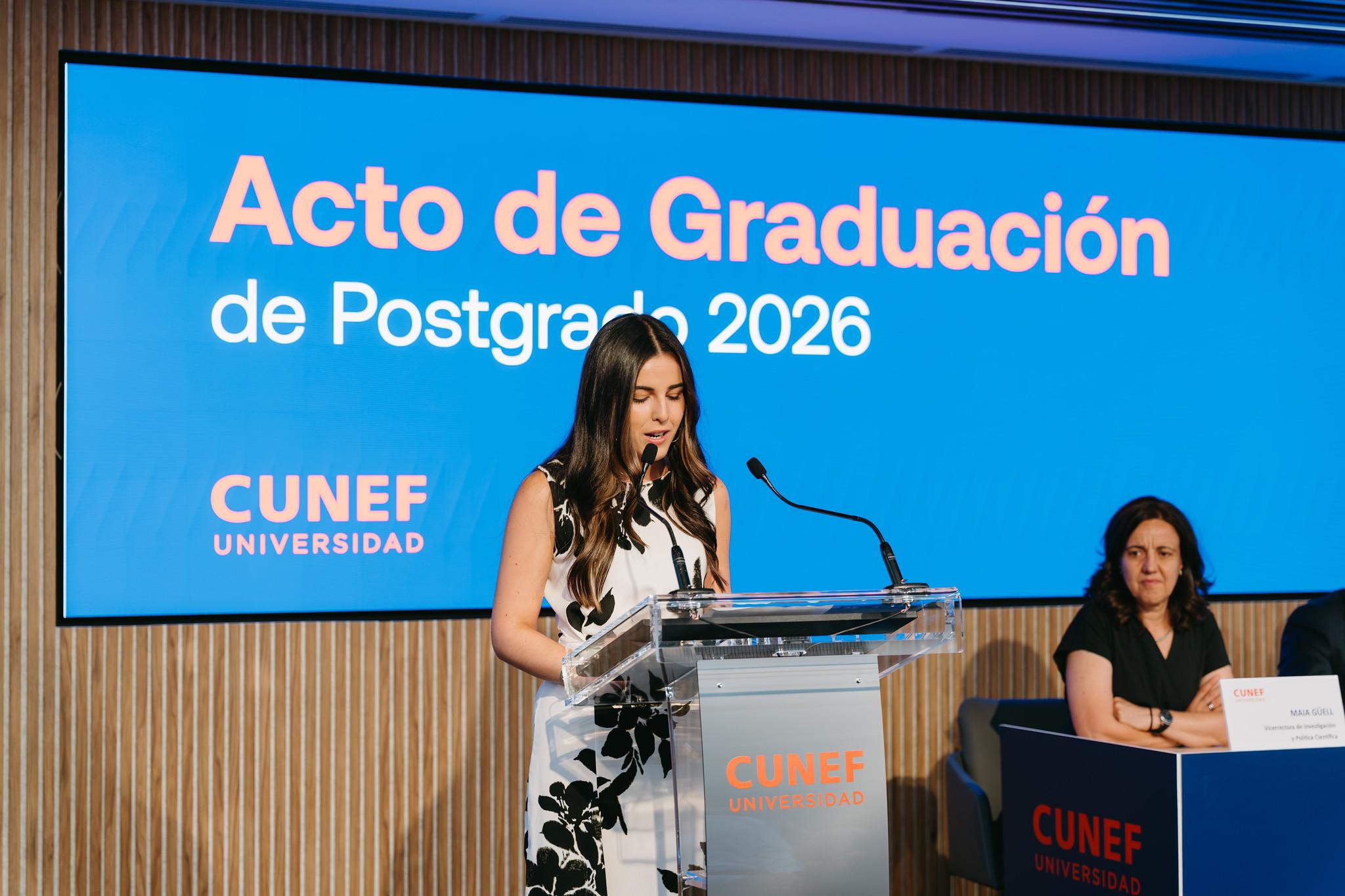 Una mujer en el podio durante un acto de graduación del posgrado 2026 en CUNEF Universidad.