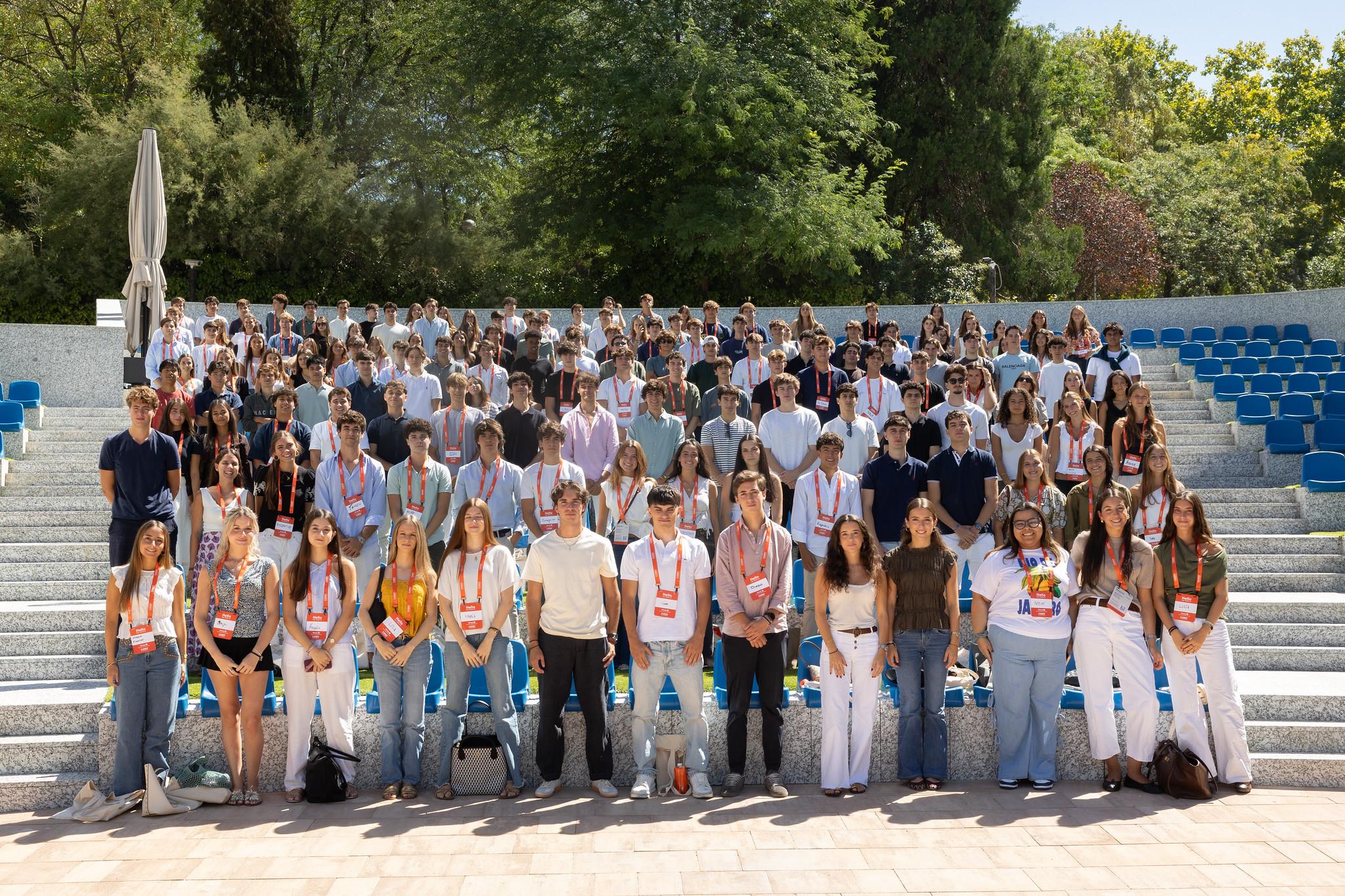 Un grupo numeroso de personas posando en un auditorio al aire libre.