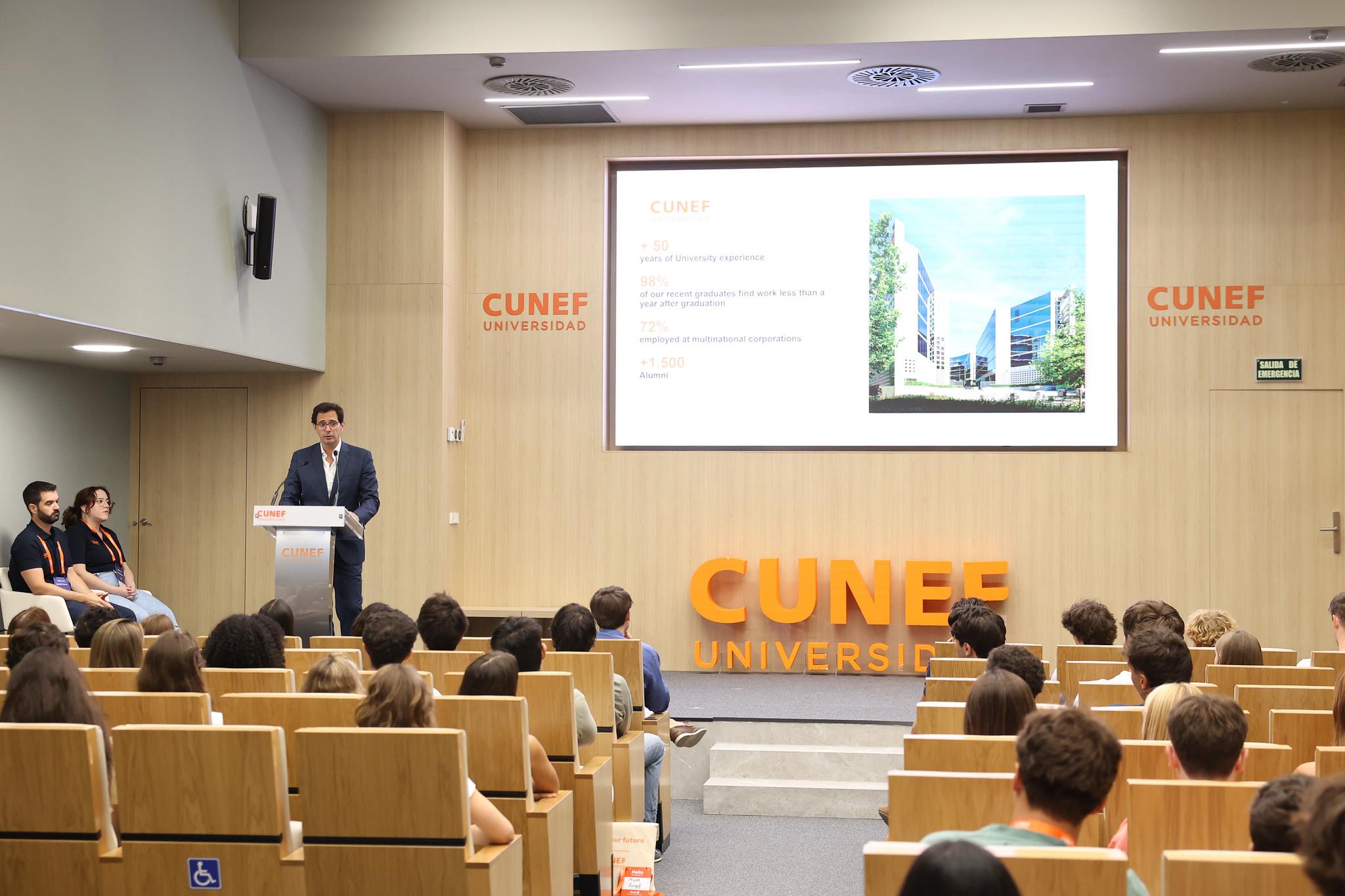 Un conferenciante está presentando en un auditorio de la universidad CUNEF ante un grupo de estudiantes.