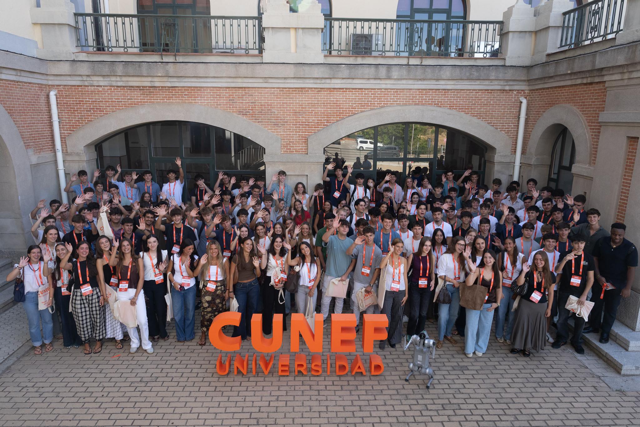 Un gran grupo de estudiantes se reúne frente a la universidad CUNEF en un evento.