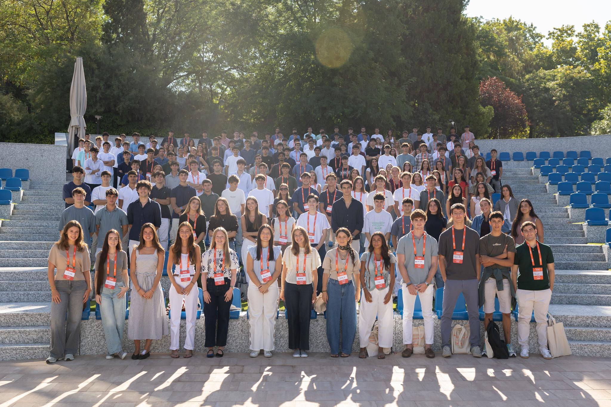 Un gran grupo de personas posando en un anfiteatro al aire libre durante un evento.