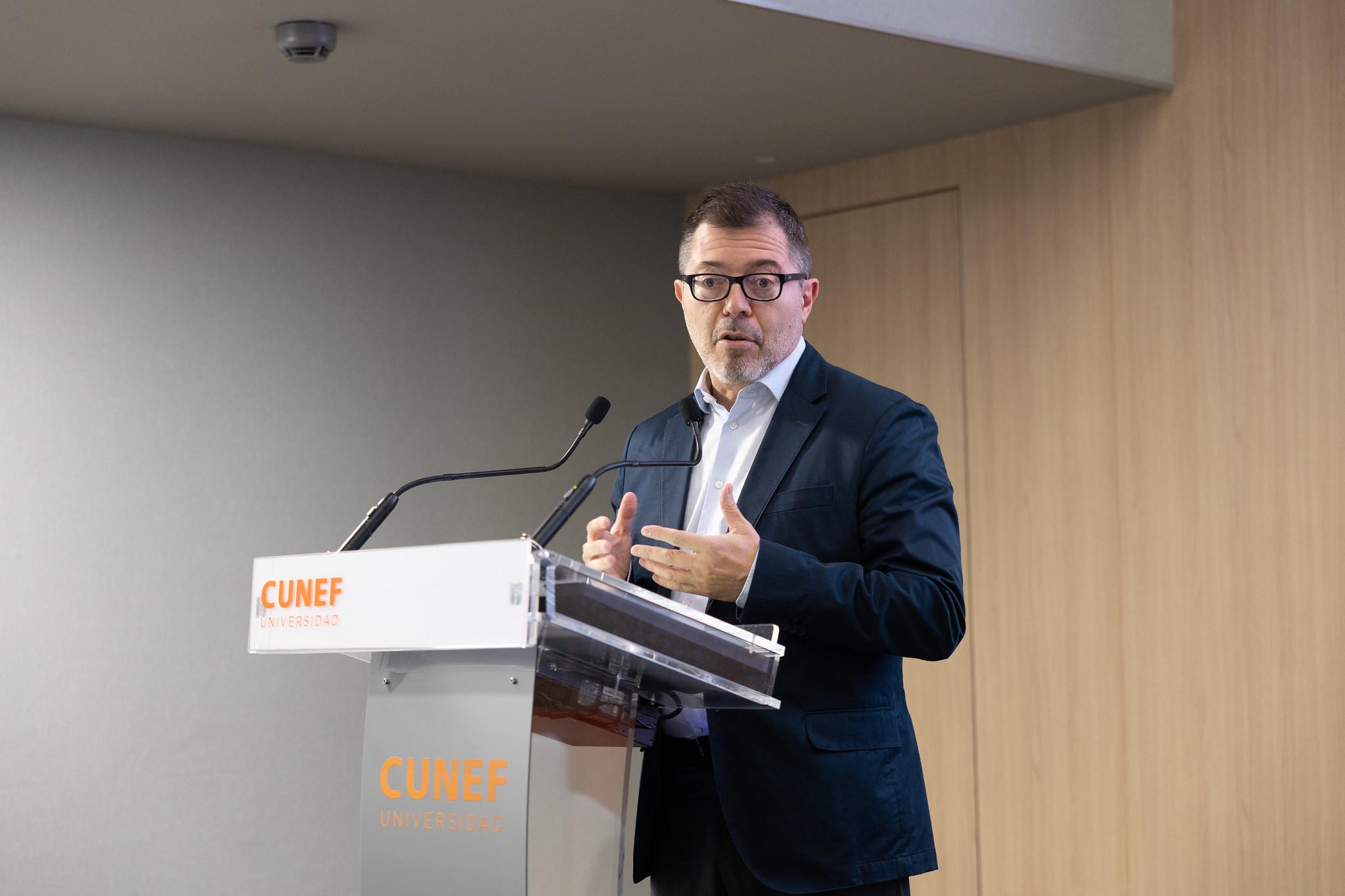 Un hombre habla en un evento frente a un podio con el logo de CUNEF.