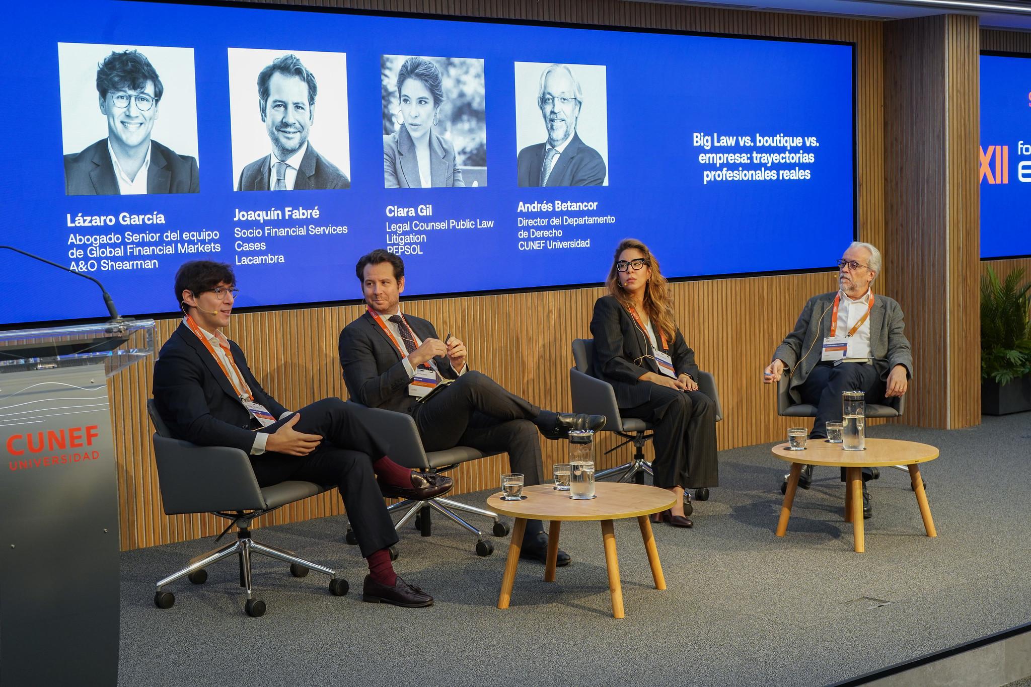 Un panel de discusión con cuatro ponentes en un evento sobre cuestiones legales y empresariales.