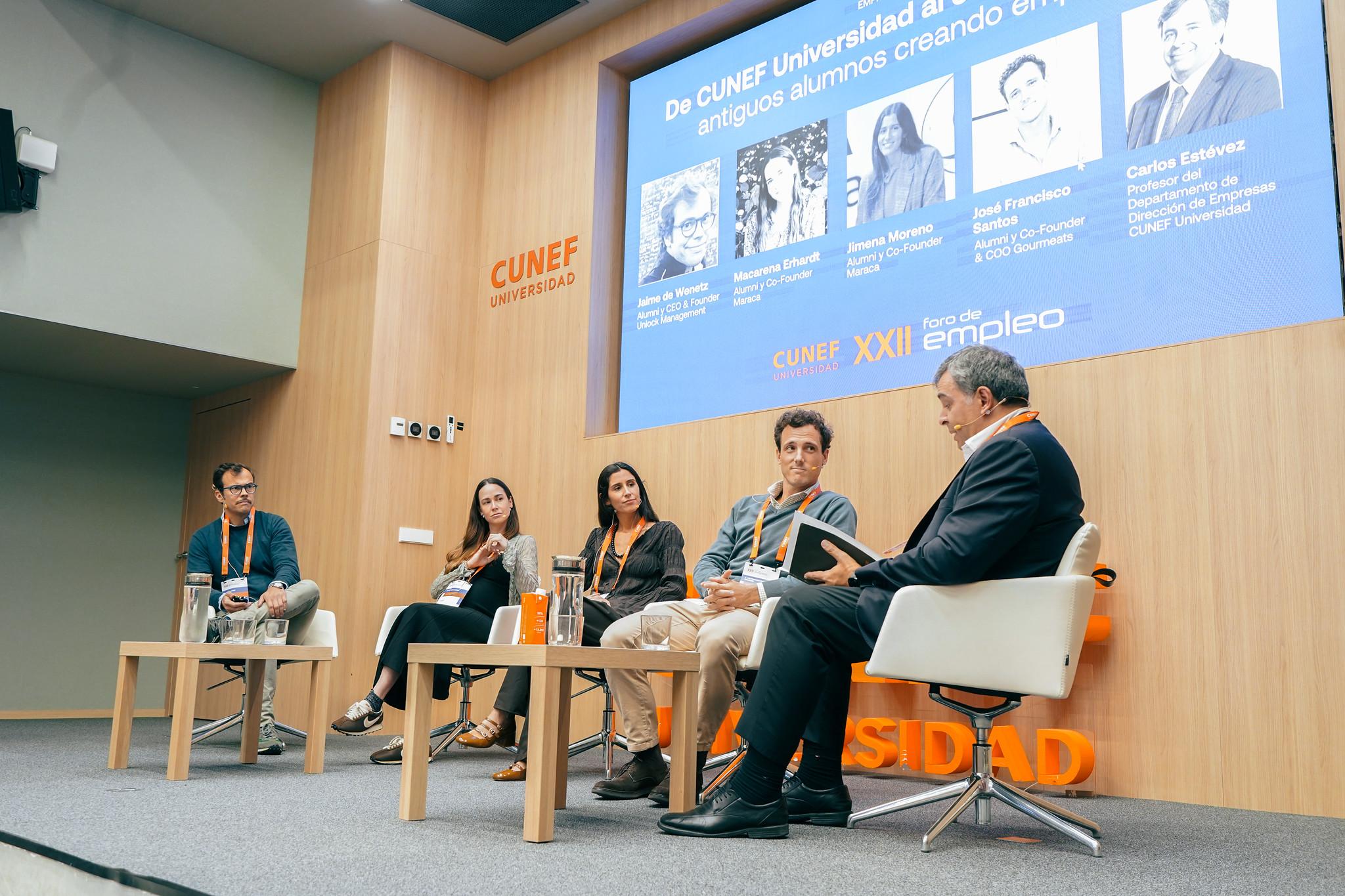 Un panel de discusión en la Universidad CUNEF, donde varios participantes conversan sobre la creación de empleo.