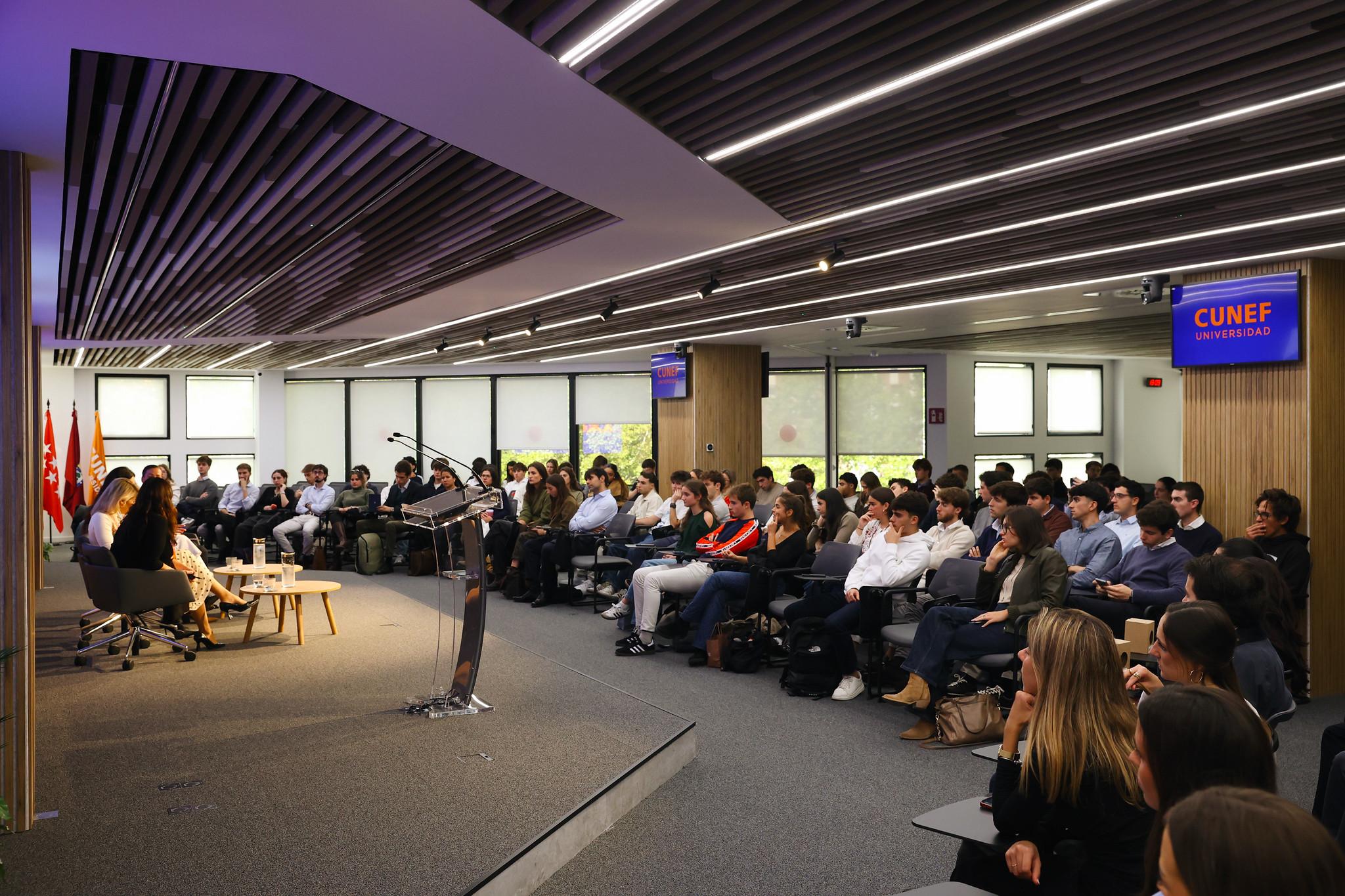 Un grupo de personas asistiendo a un evento en un auditorio moderno.