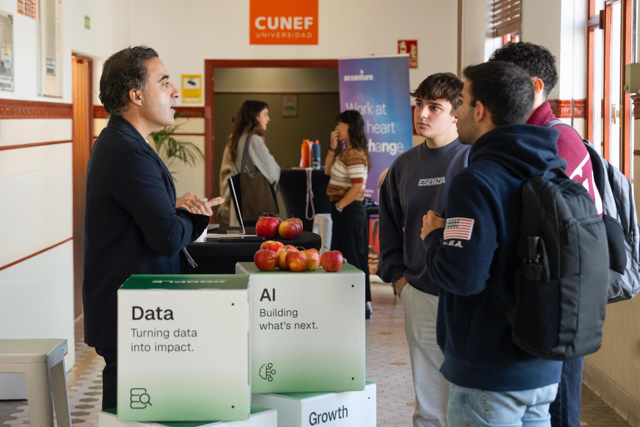 Un grupo de estudiantes intercambia ideas con un presentador sobre temas de datos y inteligencia artificial en un evento académico.