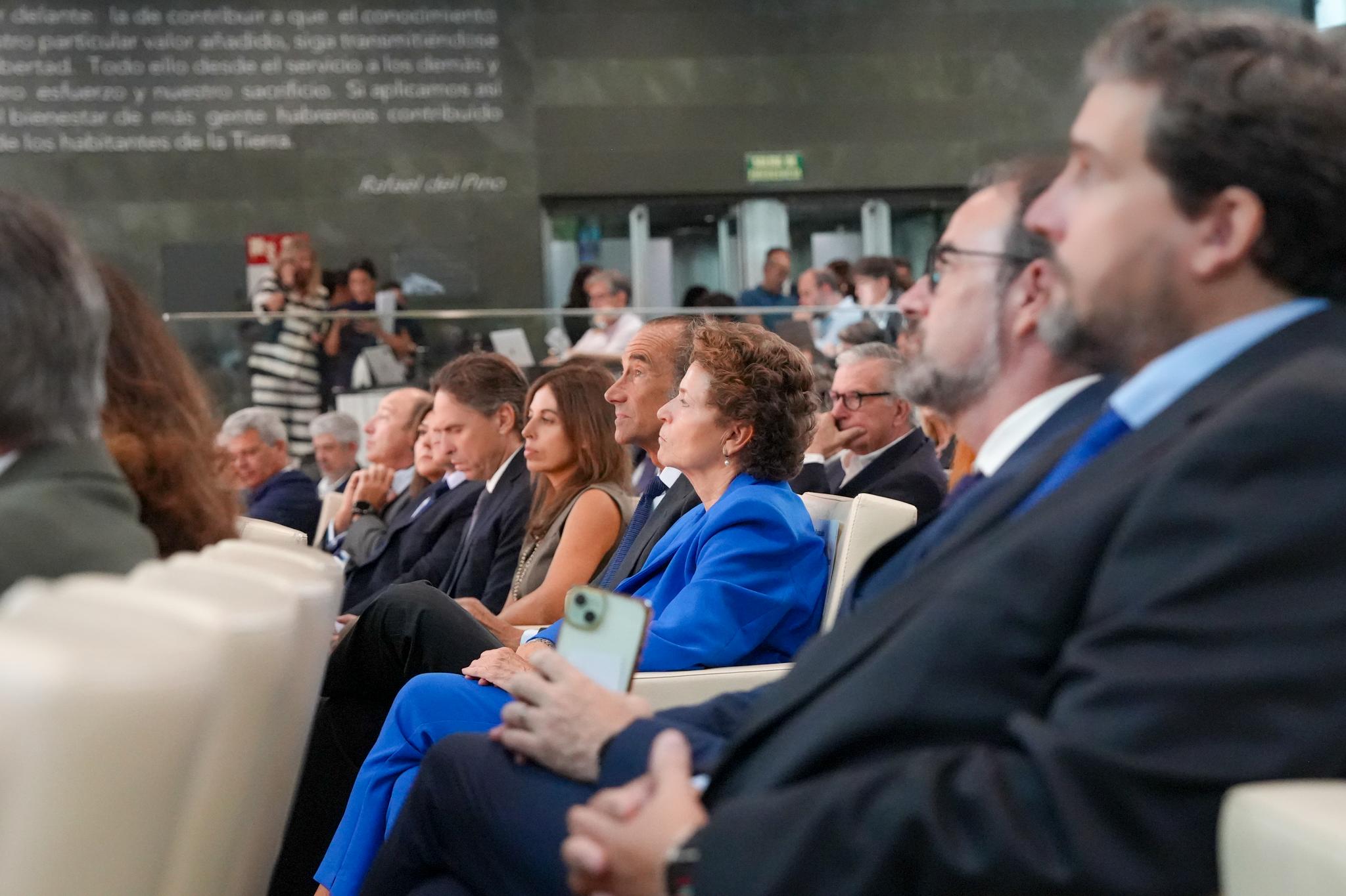 Un grupo de personas sentadas en un evento, escuchando atentamente desde la primera fila.