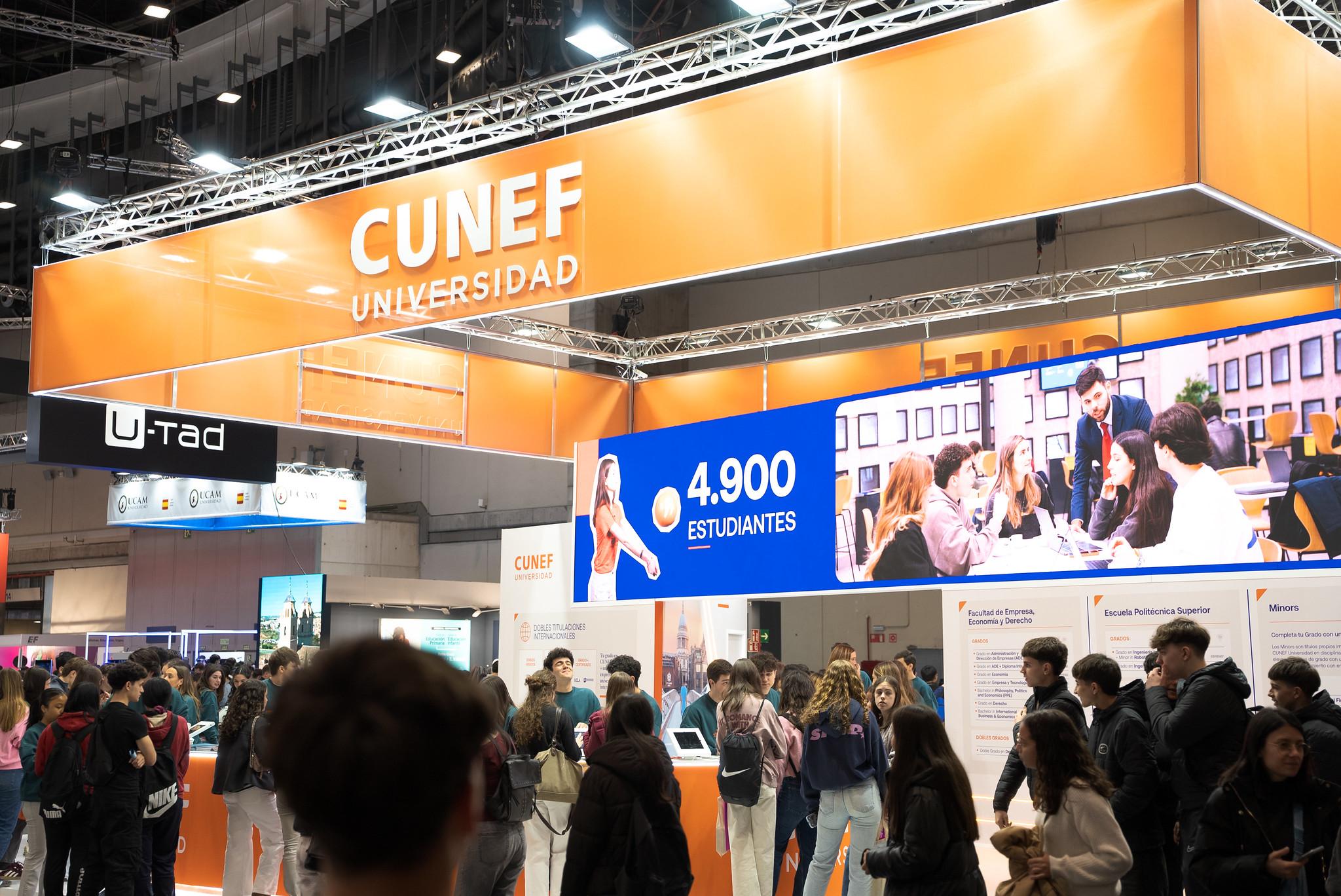Un evento educativo con un stand de la Universidad CUNEF que presenta información sobre sus estudiantes.