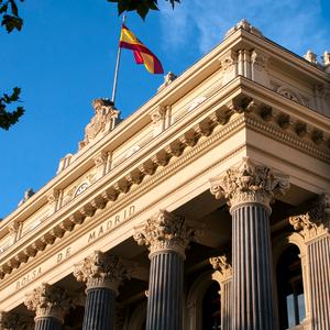 Una vista del edificio de la Bolsa de Madrid con la bandera española ondeando.