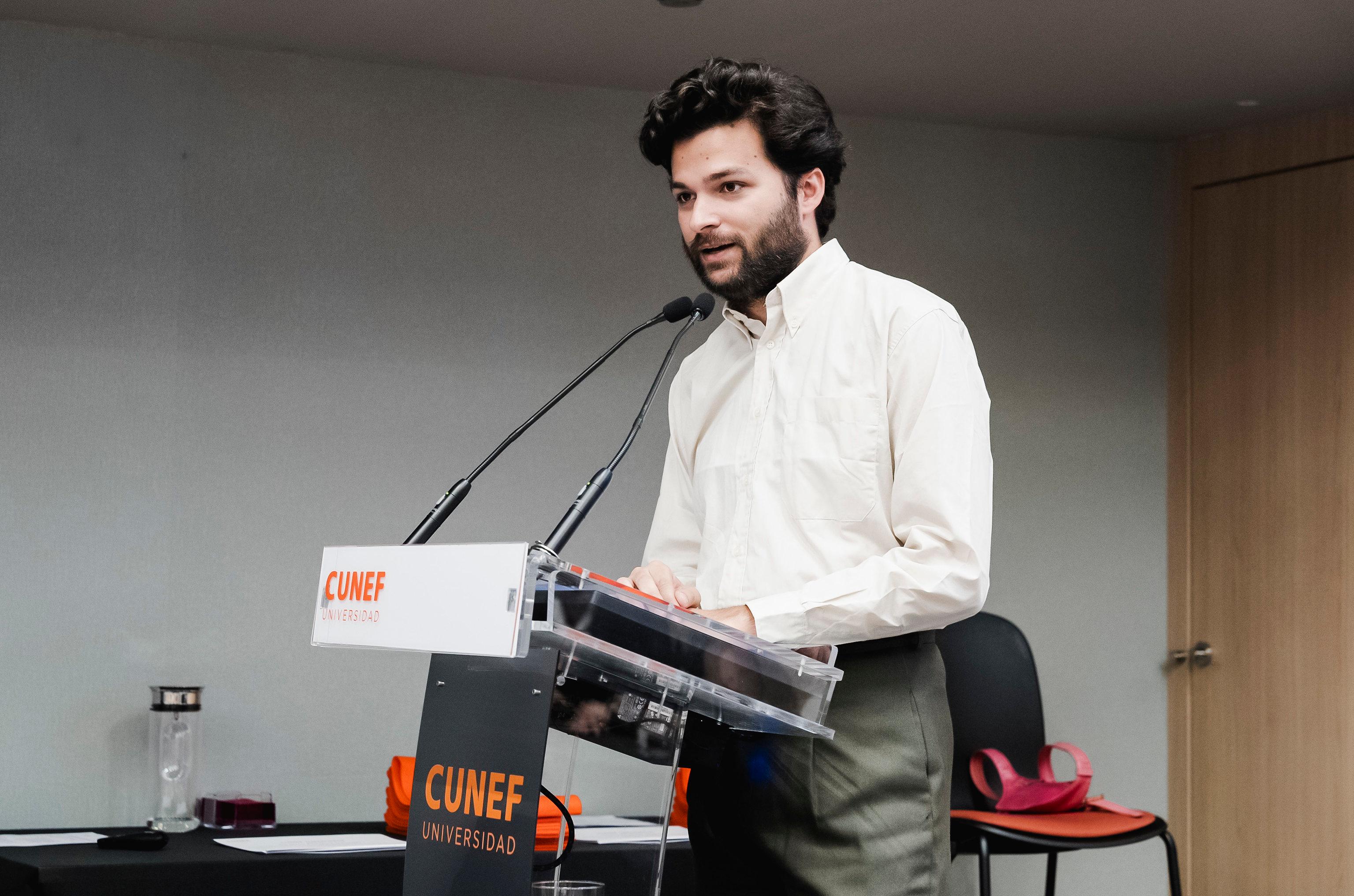Un hombre se presenta en un podio durante un evento en la universidad CUNEF.