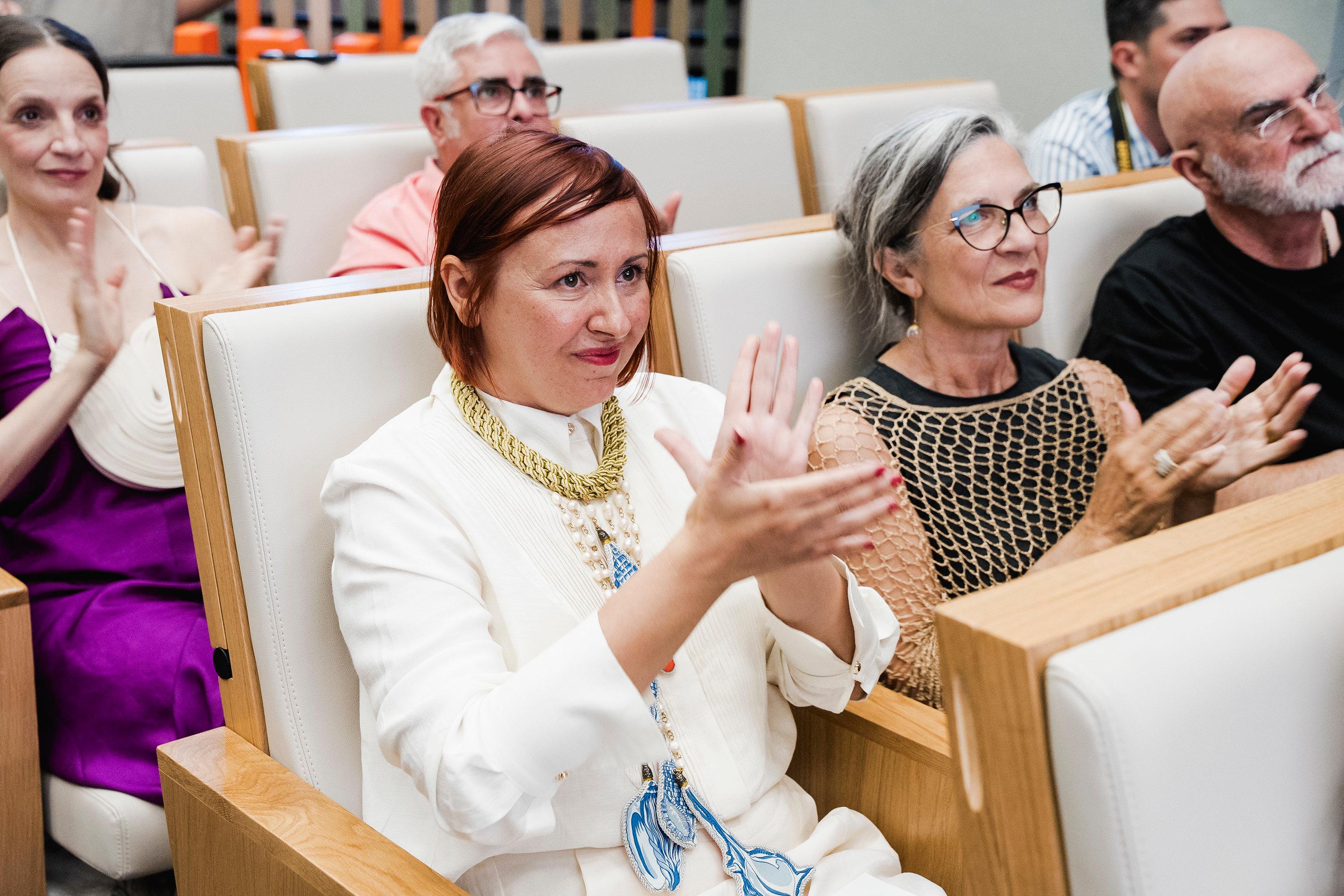 Un grupo de personas aplaudiendo en un evento formal.