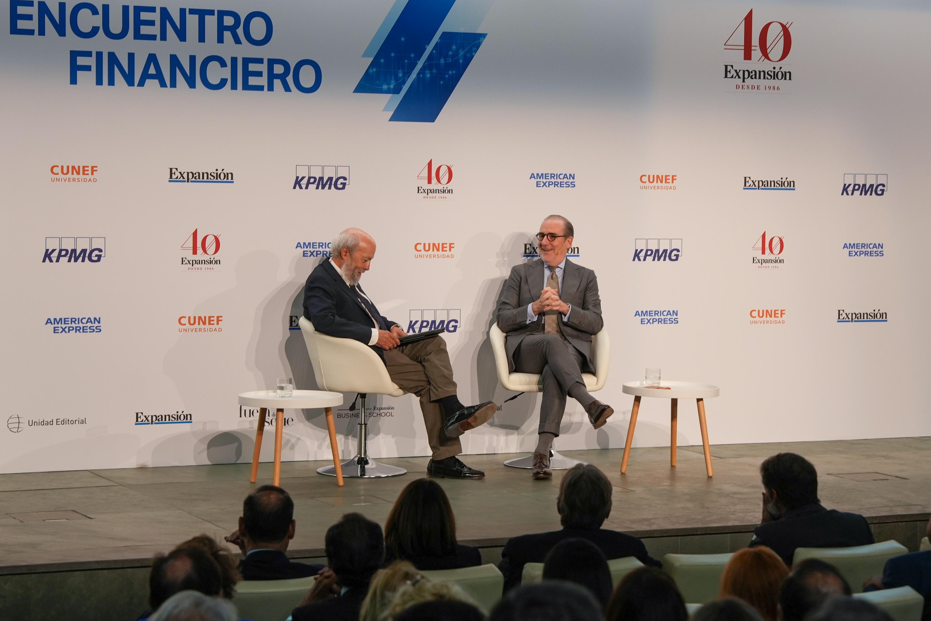 Un evento de discusión financiera con dos ponentes en un escenario.