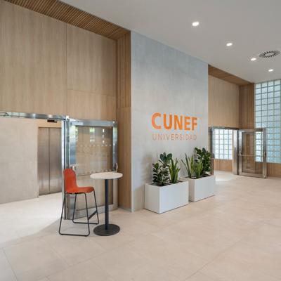 Interior moderno de la Universidad CUNEF con una entrada espaciosa y decoración minimalista.