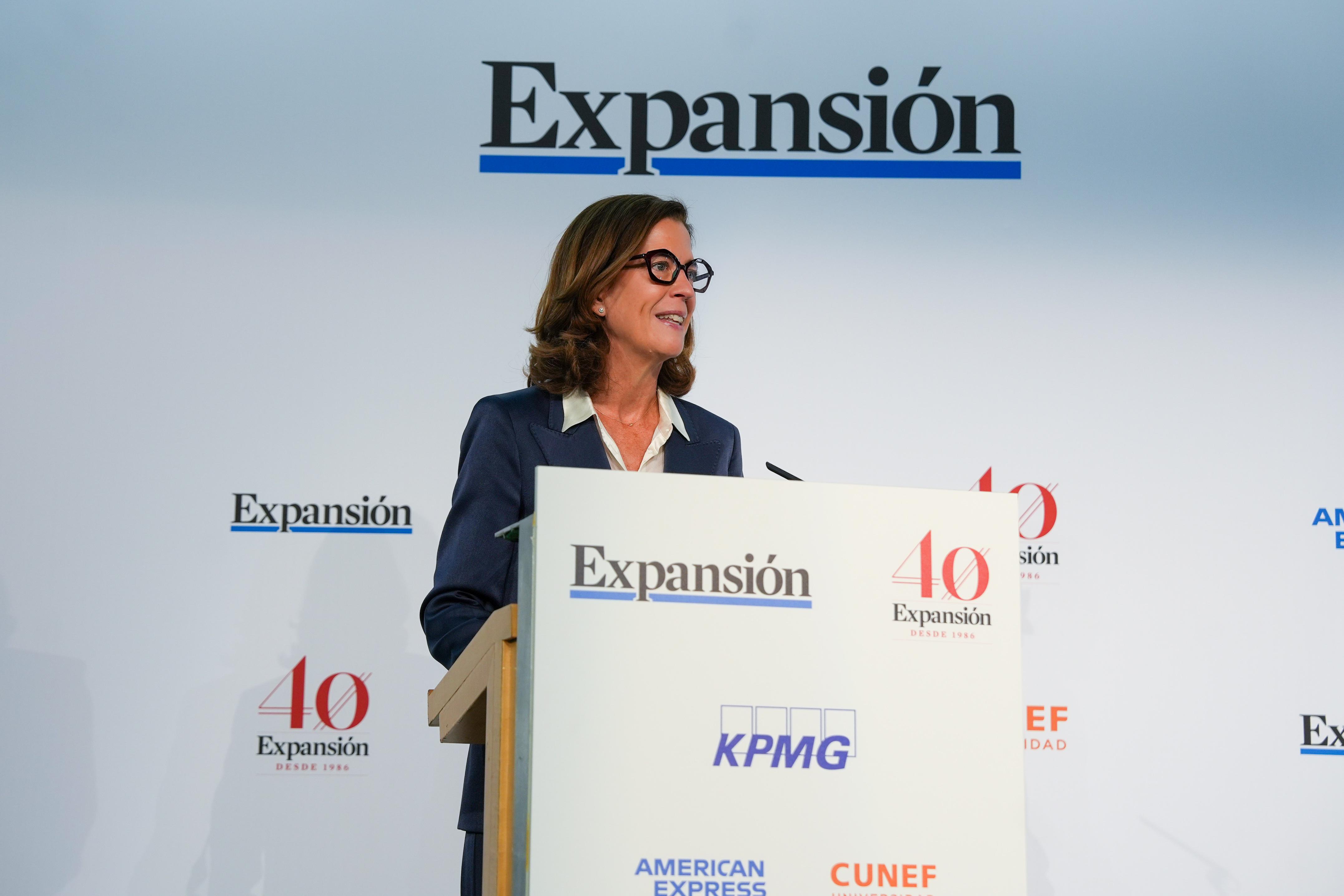 Una mujer sonriente habla en un evento de celebración del 40 aniversario de un medio de comunicación.