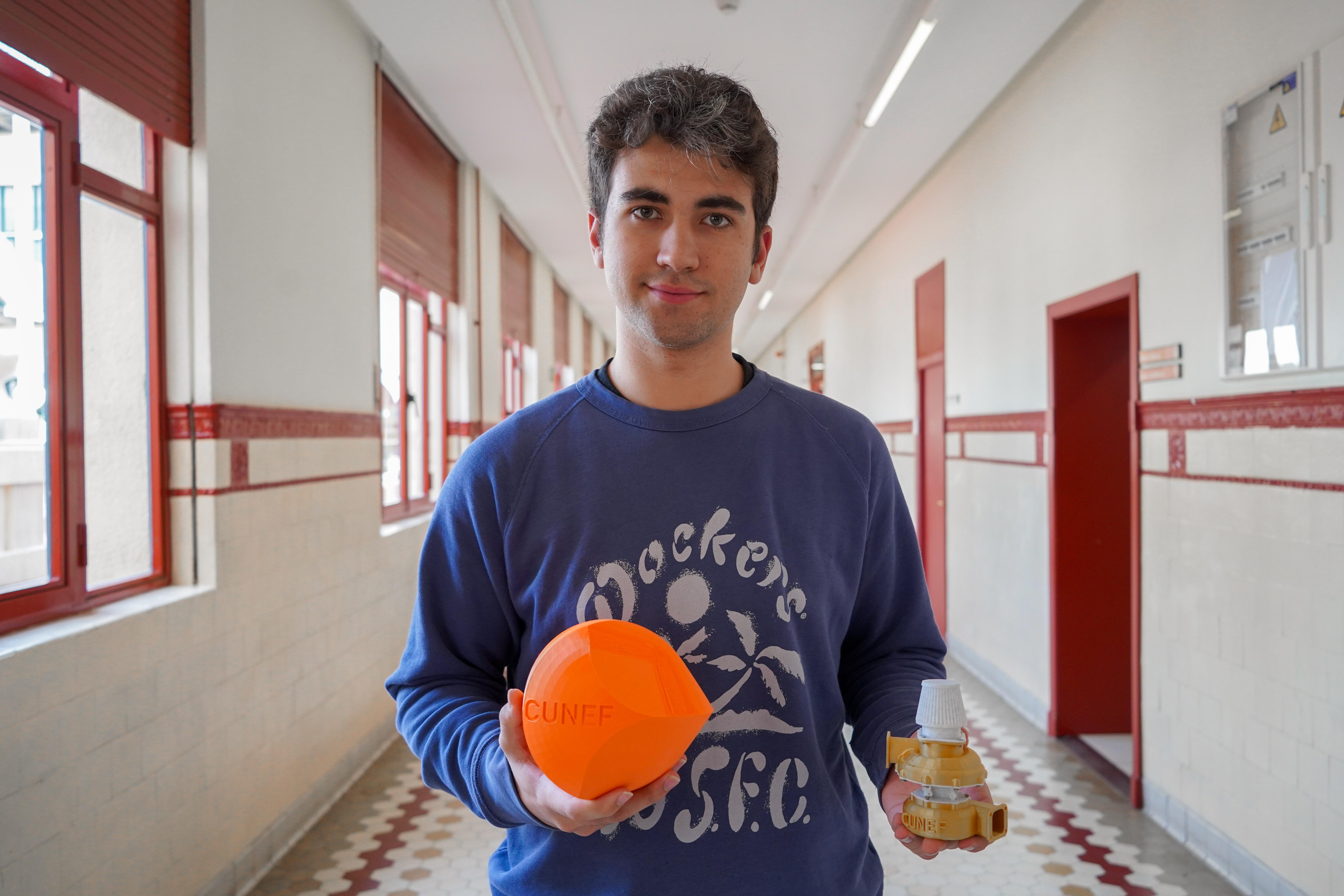 Un joven sostiene una pelota naranja y un frasco en un pasillo escolar.