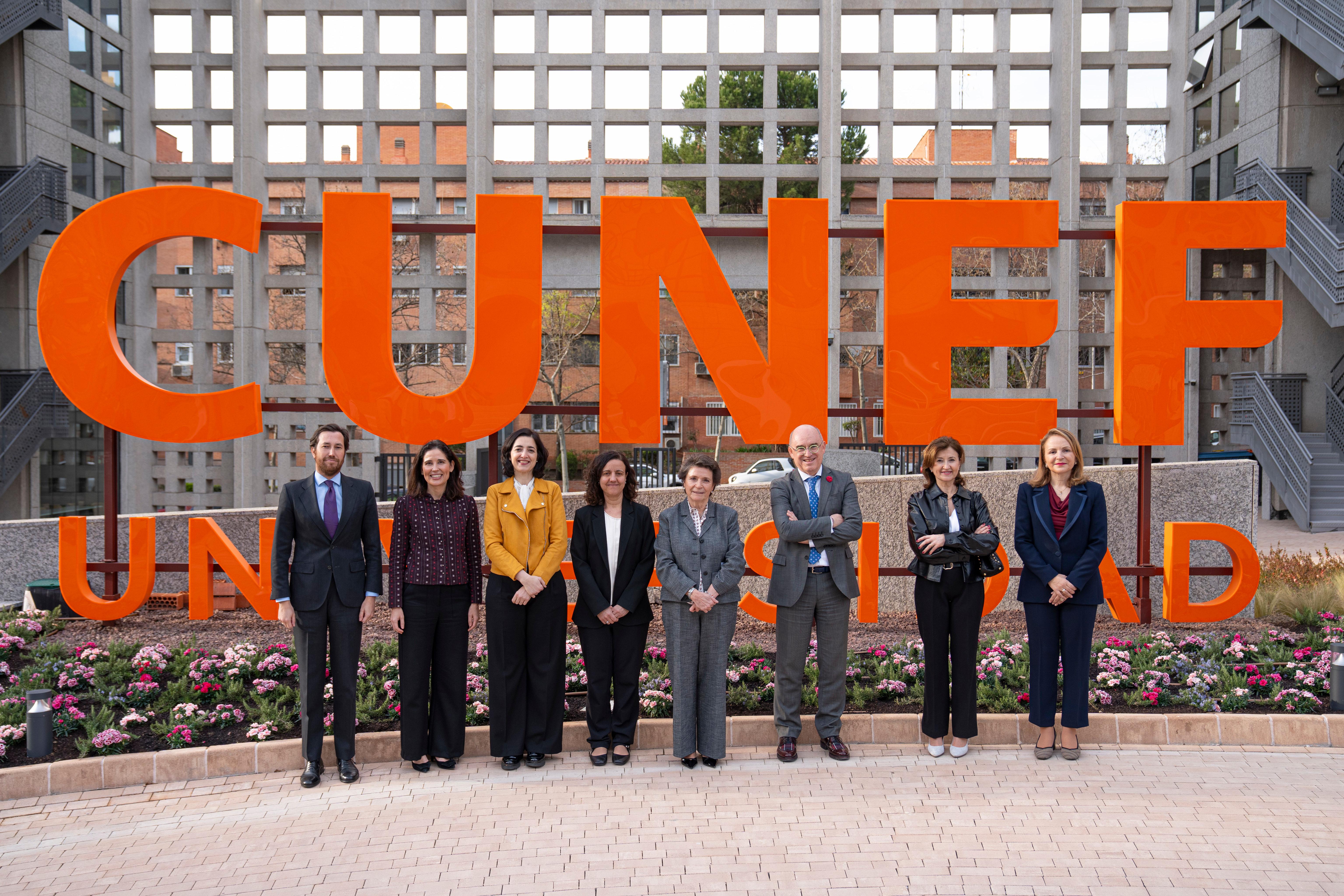 Un grupo de personas posa frente al letrero de la Universidad CUNEF.