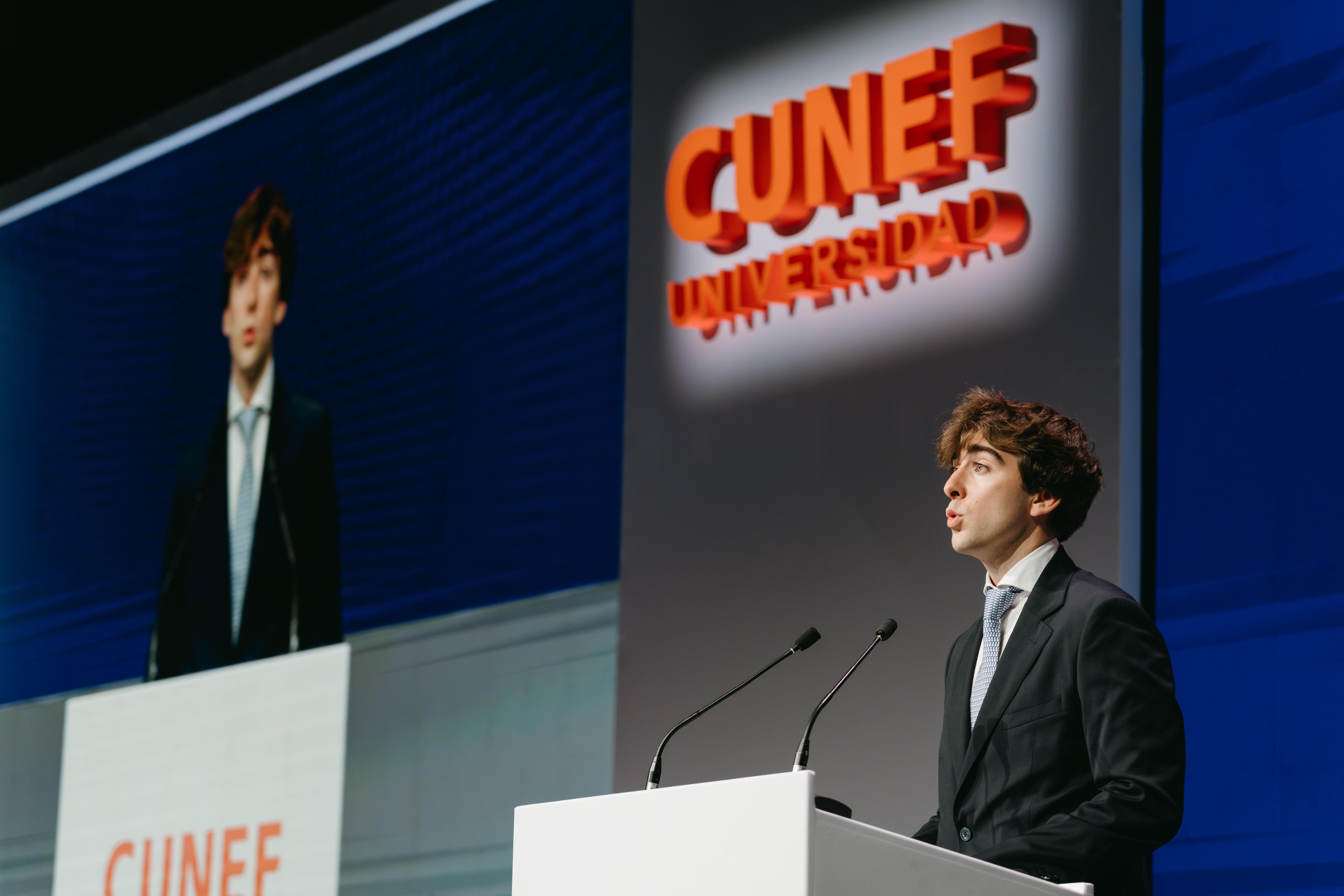 Un joven habla en un podio durante un evento de la universidad CUNEF.