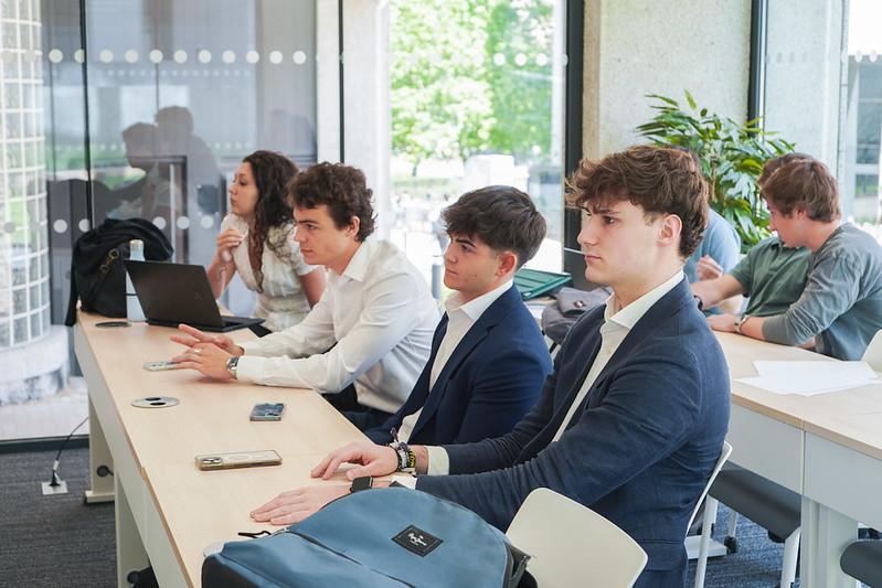 Un grupo de jóvenes sentados en una sala de clases prestando atención durante una presentación.