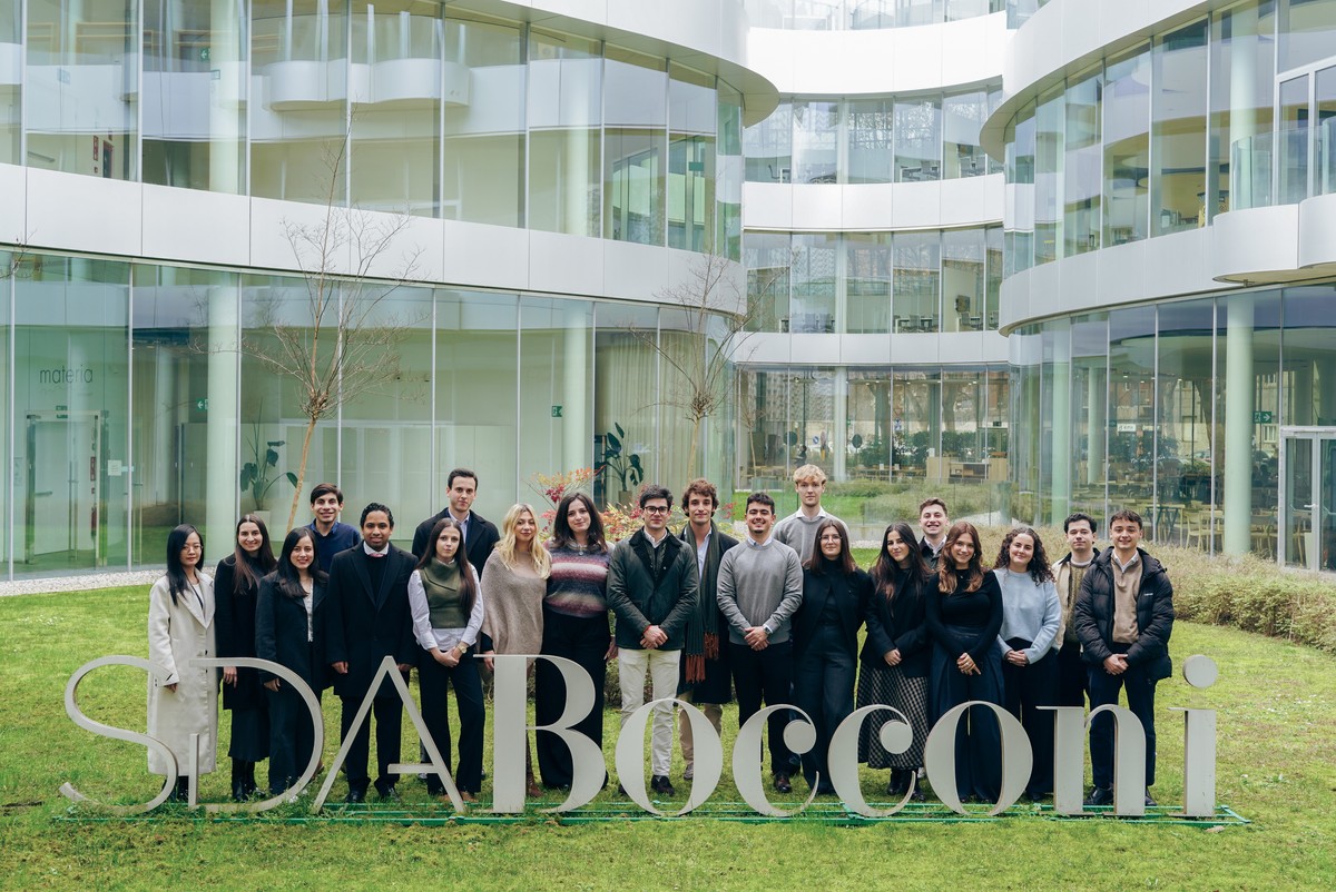 Grupo de personas posando frente a un edificio moderno de la SDA Bocconi.