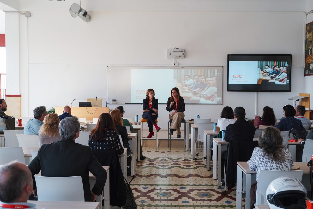 Una de las charlas del Open Day de ESP en un aula con dos ponentes sentadas en un escenario y una audiencia atenta.