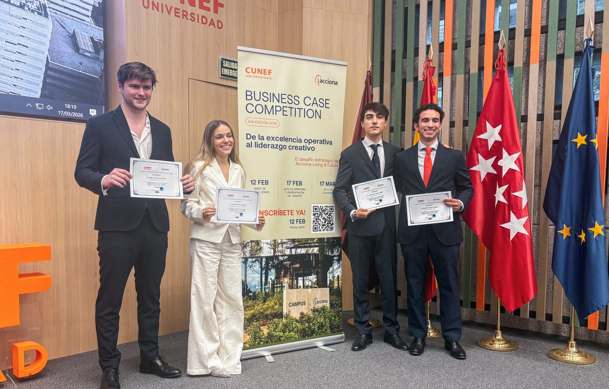 Cuatro jóvenes sostienen diplomas en un evento de competencia empresarial.