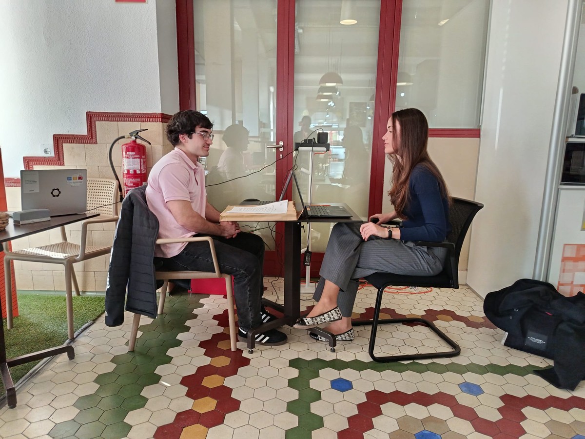 Dos personas conversando en un espacio moderno y acogedor.