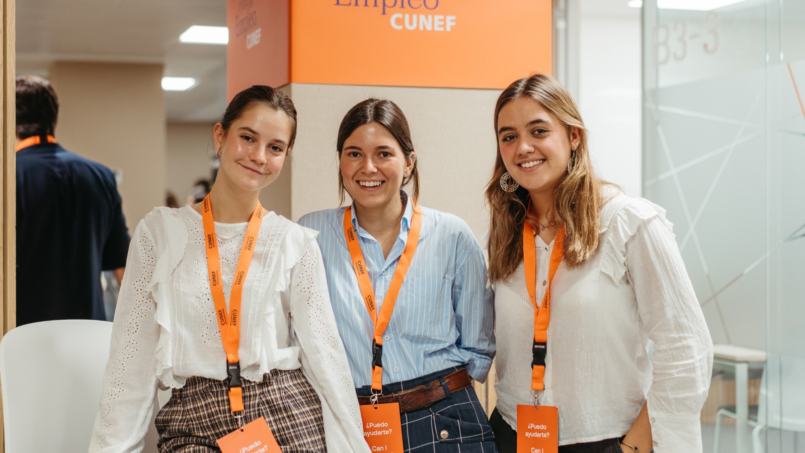 Tres mujeres sonrientes posan juntas en un evento relacionado con el empleo.